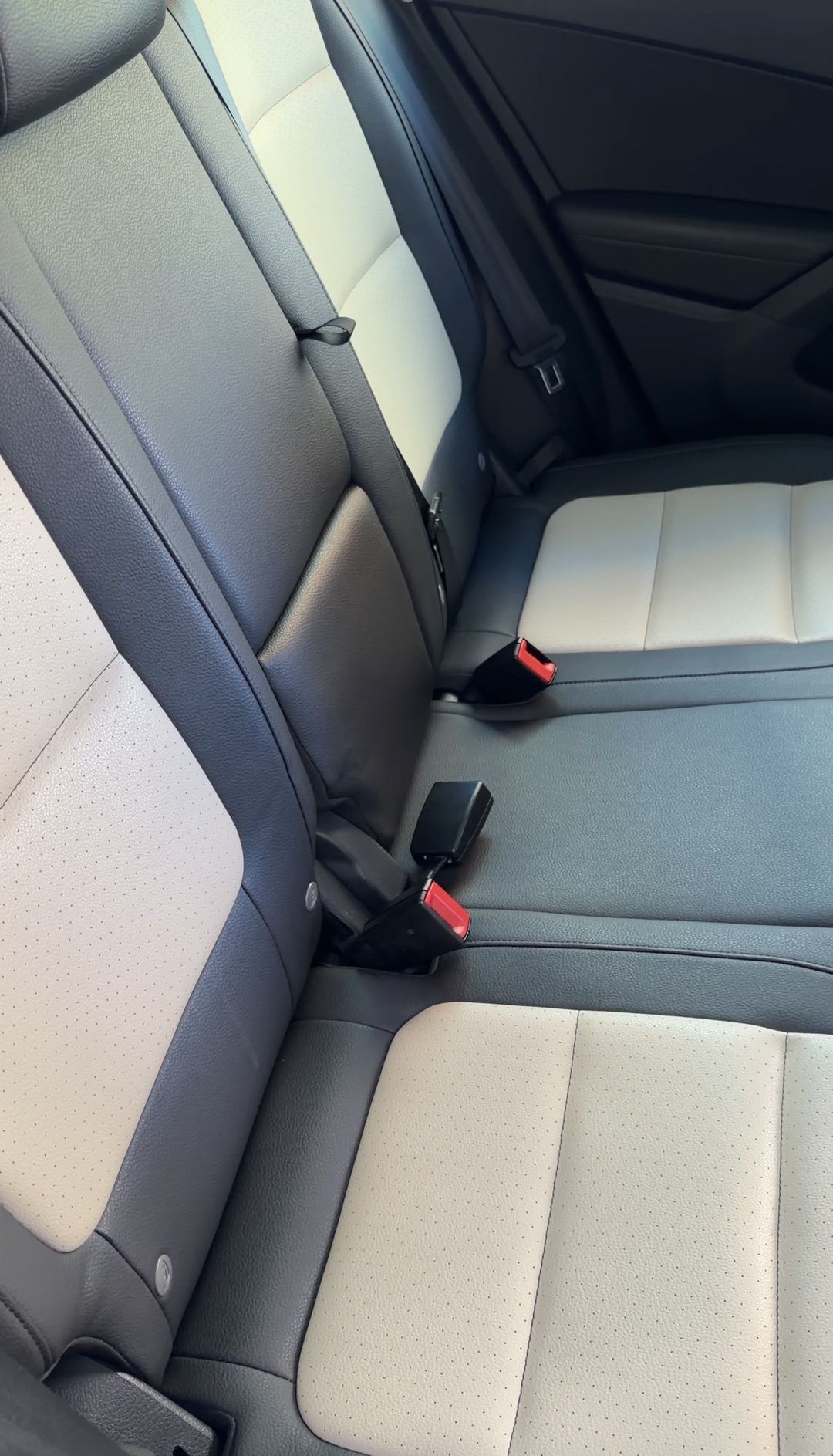 Clean rear bench seats of a VW Tiguan in two-tone black and beige perforated upholstery.
