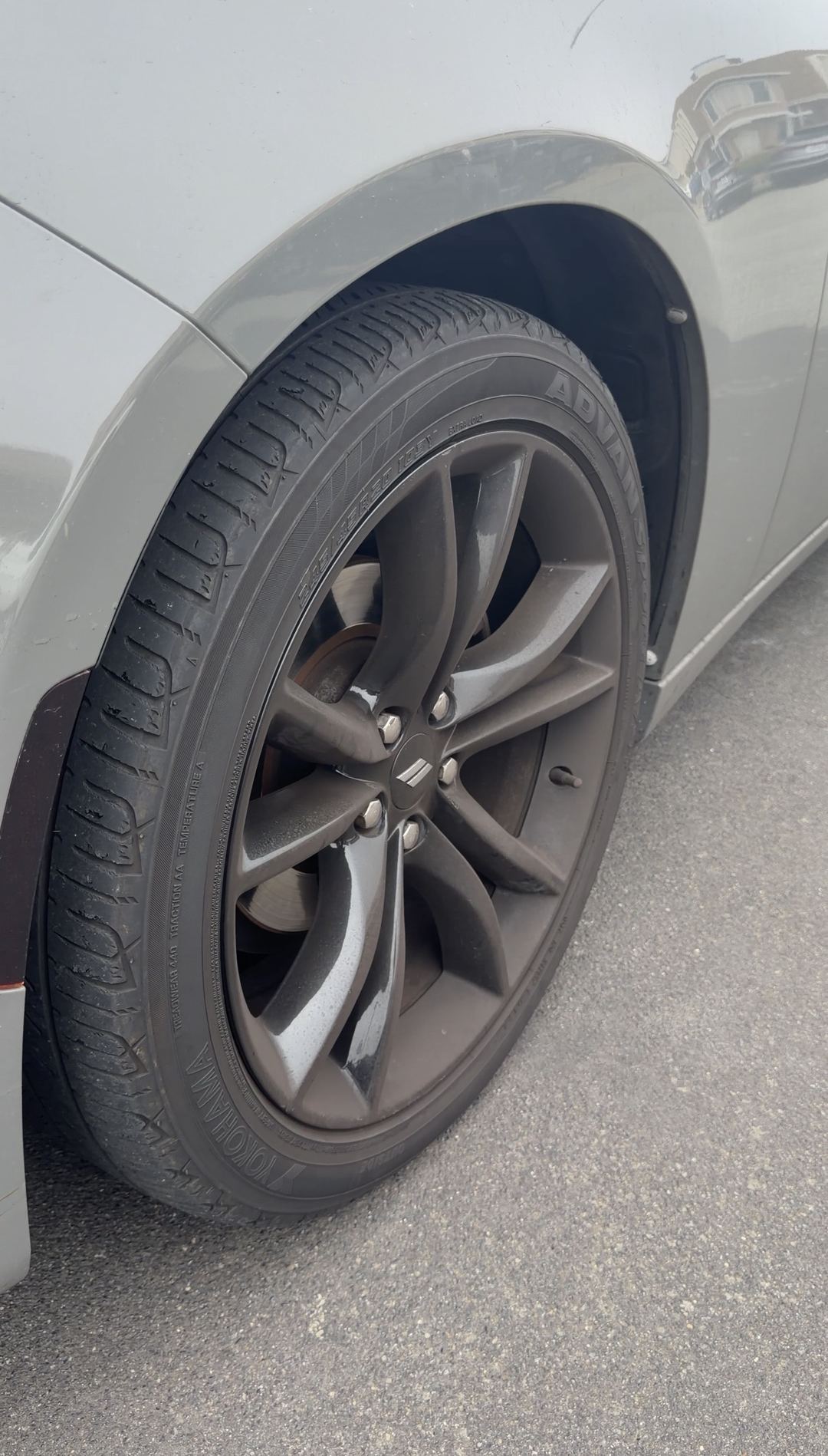 Dodge Charger black wheel coated in brown brake dust before cleaning