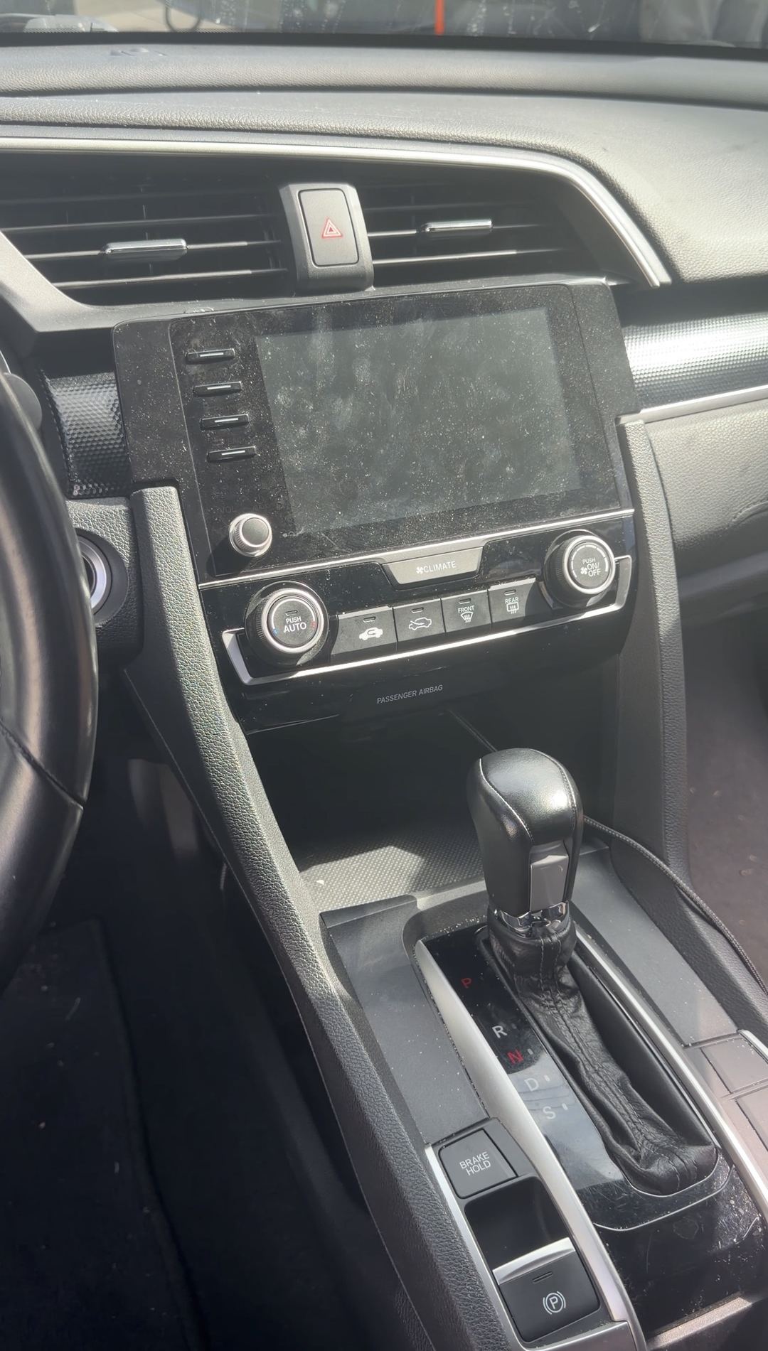 Dust-covered touchscreen and shifter in a Honda Civic before cleaning