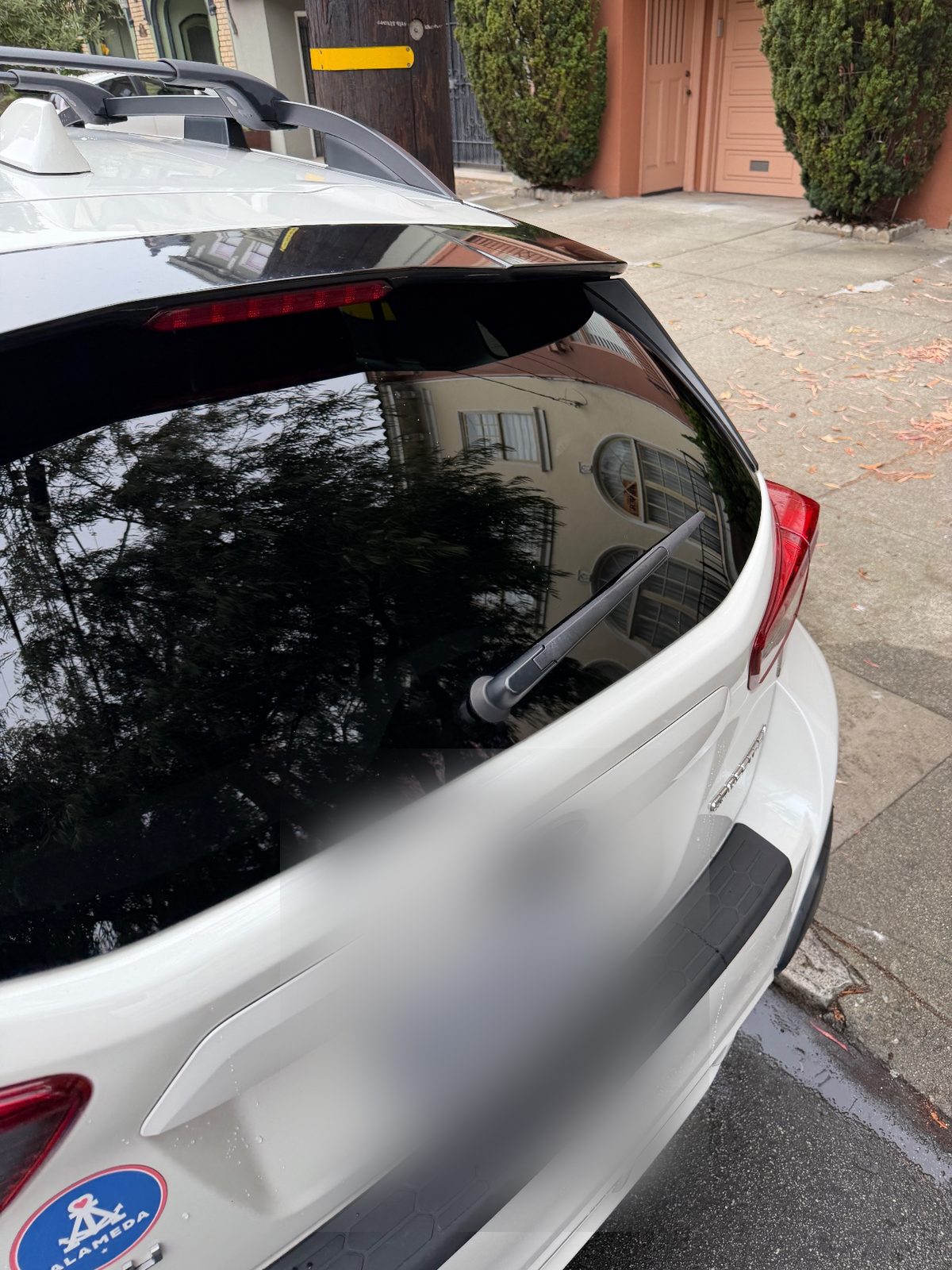 Close view of a clean rear hatch glass on a white Subaru Crosstrek after washing