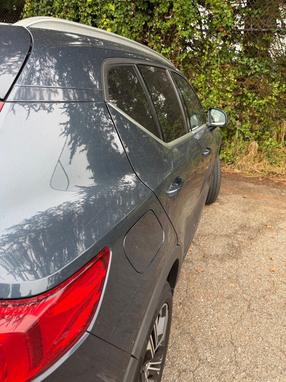 Rear right quarter of a Volvo XC40 before washing, covered in a dust film