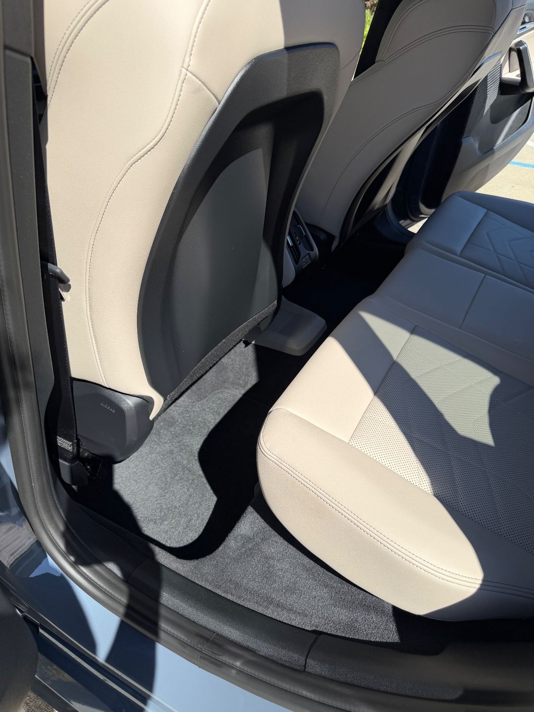 Rear footwell of a BMW X1 after vacuuming, with fresh vacuum lines in the carpet