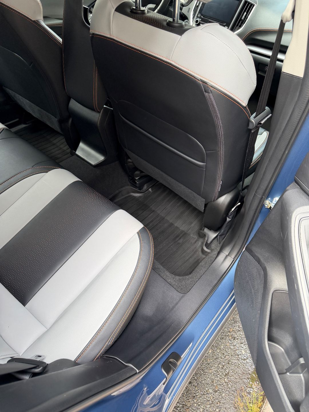 Clean rear passenger-side footwell of a Subaru Crosstrek after detailing, the rubber mat back in place
