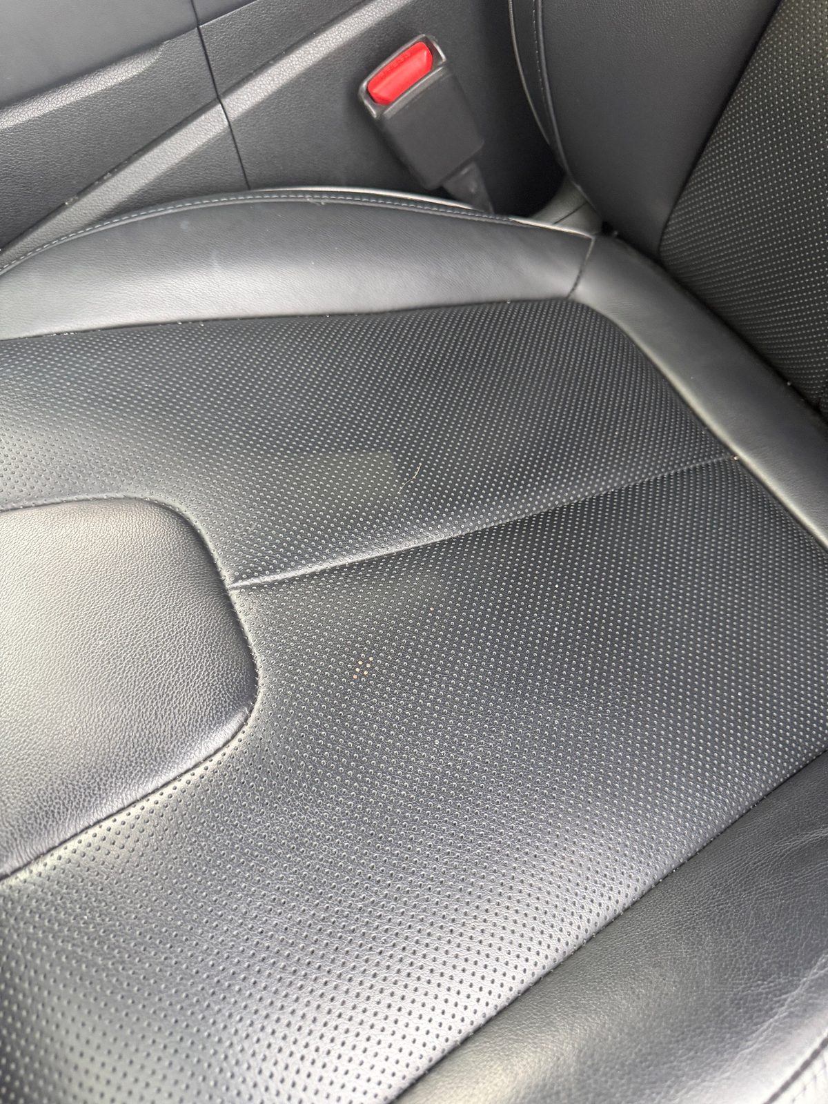 Close-up of grey-black perforated leather seat of a Hyundai Santa Fe before detailing