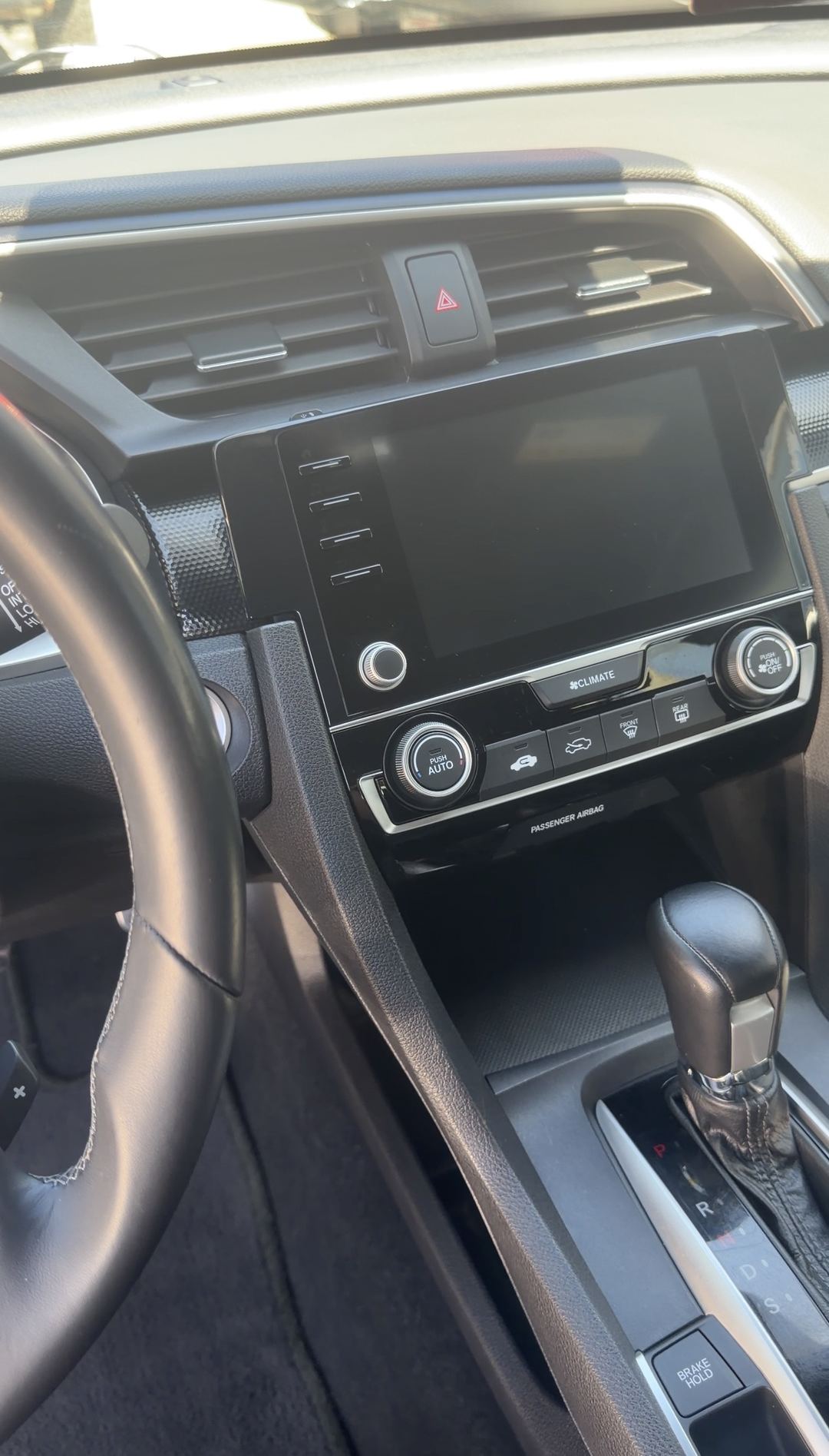 Clean touchscreen and shifter in a Honda Civic after interior cleaning