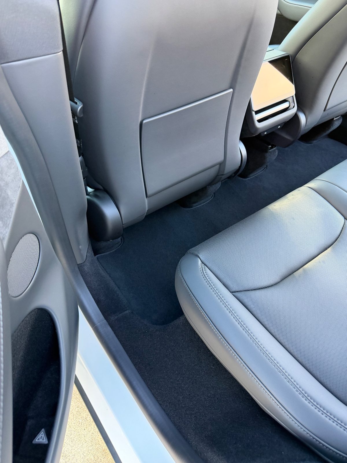 Clean rear footwell of a white Tesla Model Y after vacuuming