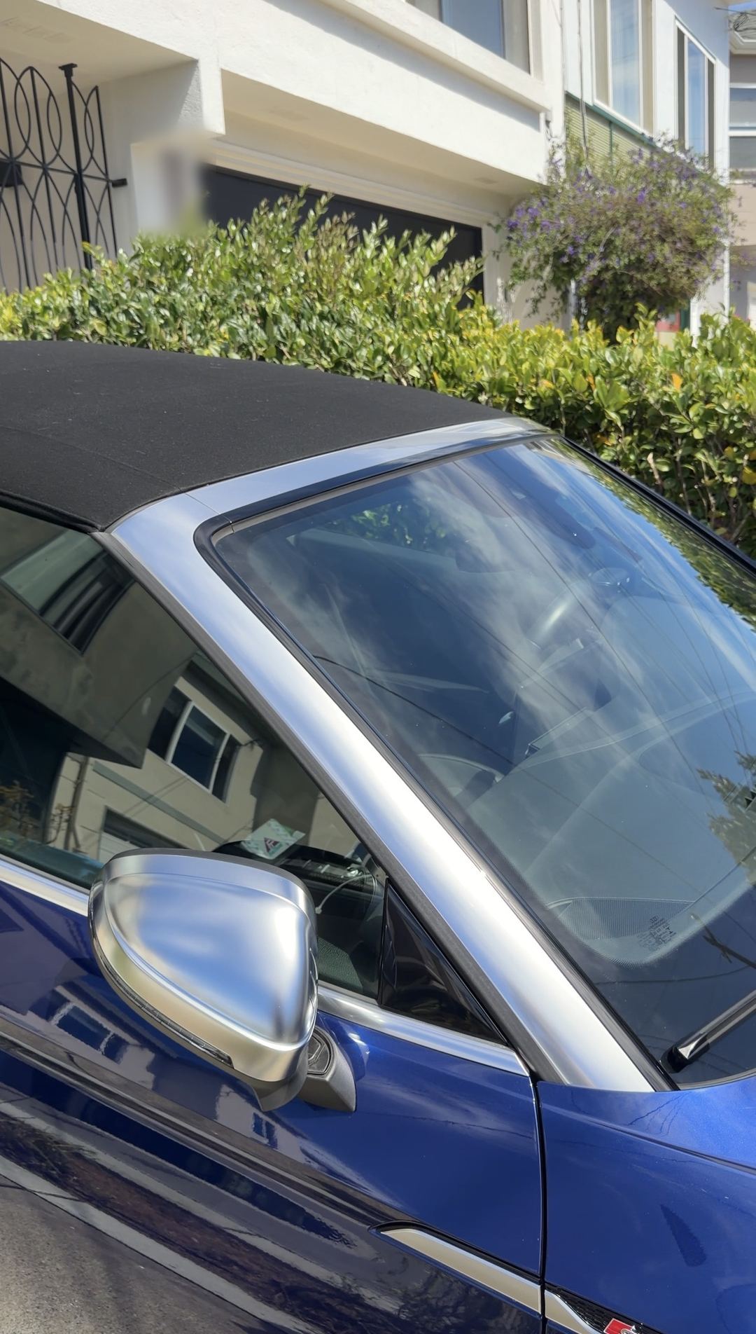 Silver mirror cap and clean soft top edge of a blue Audi S5 Cabriolet