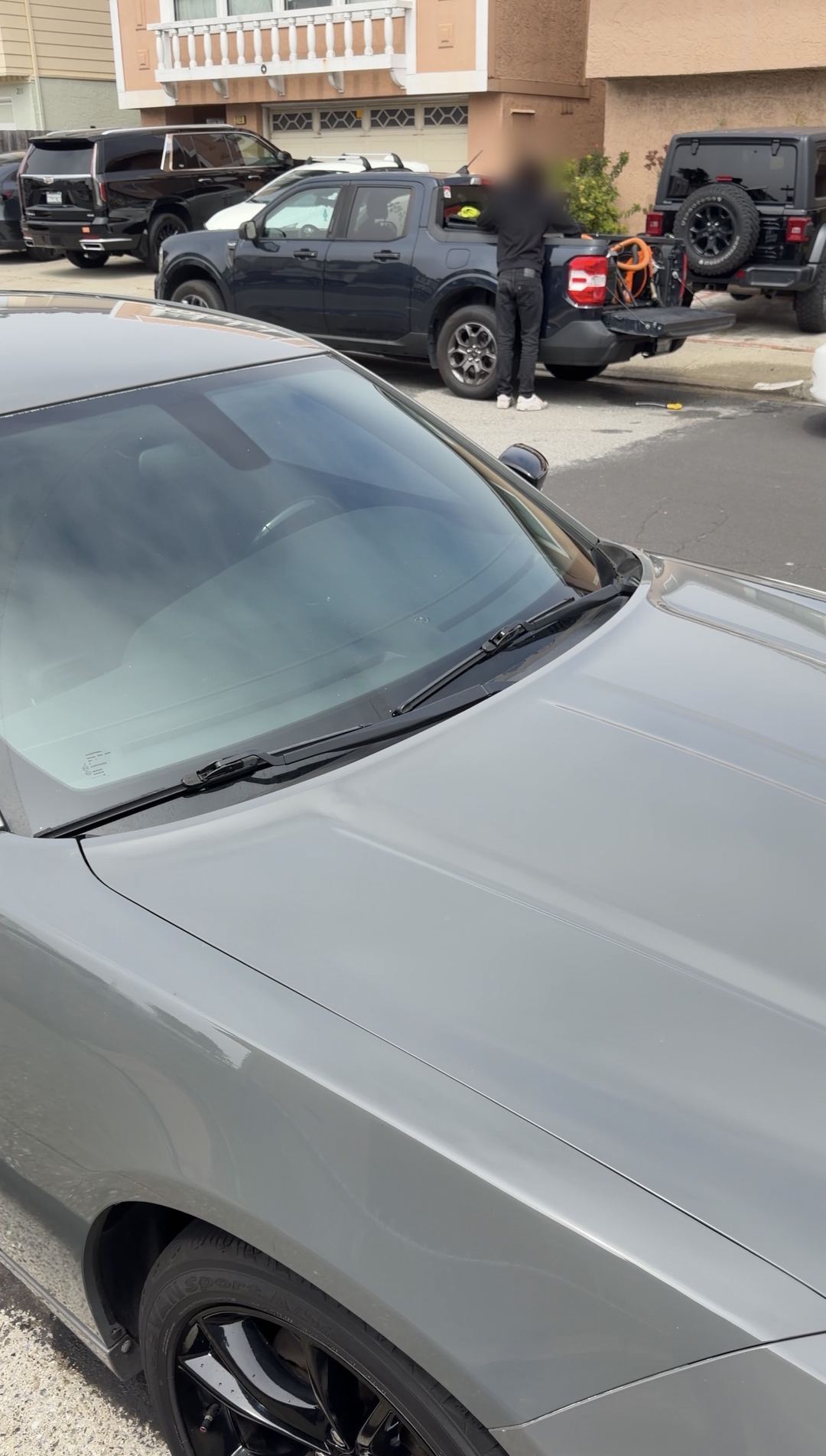 Clean grey Dodge Charger windshield and hood on a residential street after cleaning