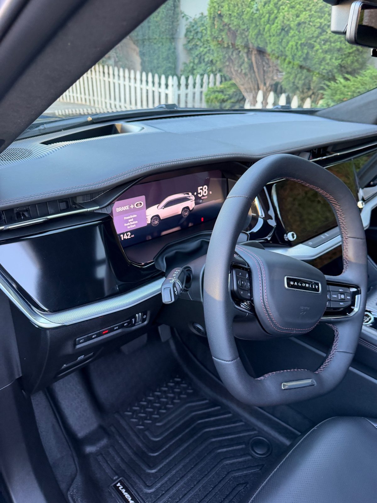 Clean cockpit of a Jeep Wagoneer S with the Wagoneer steering wheel badge after detailing