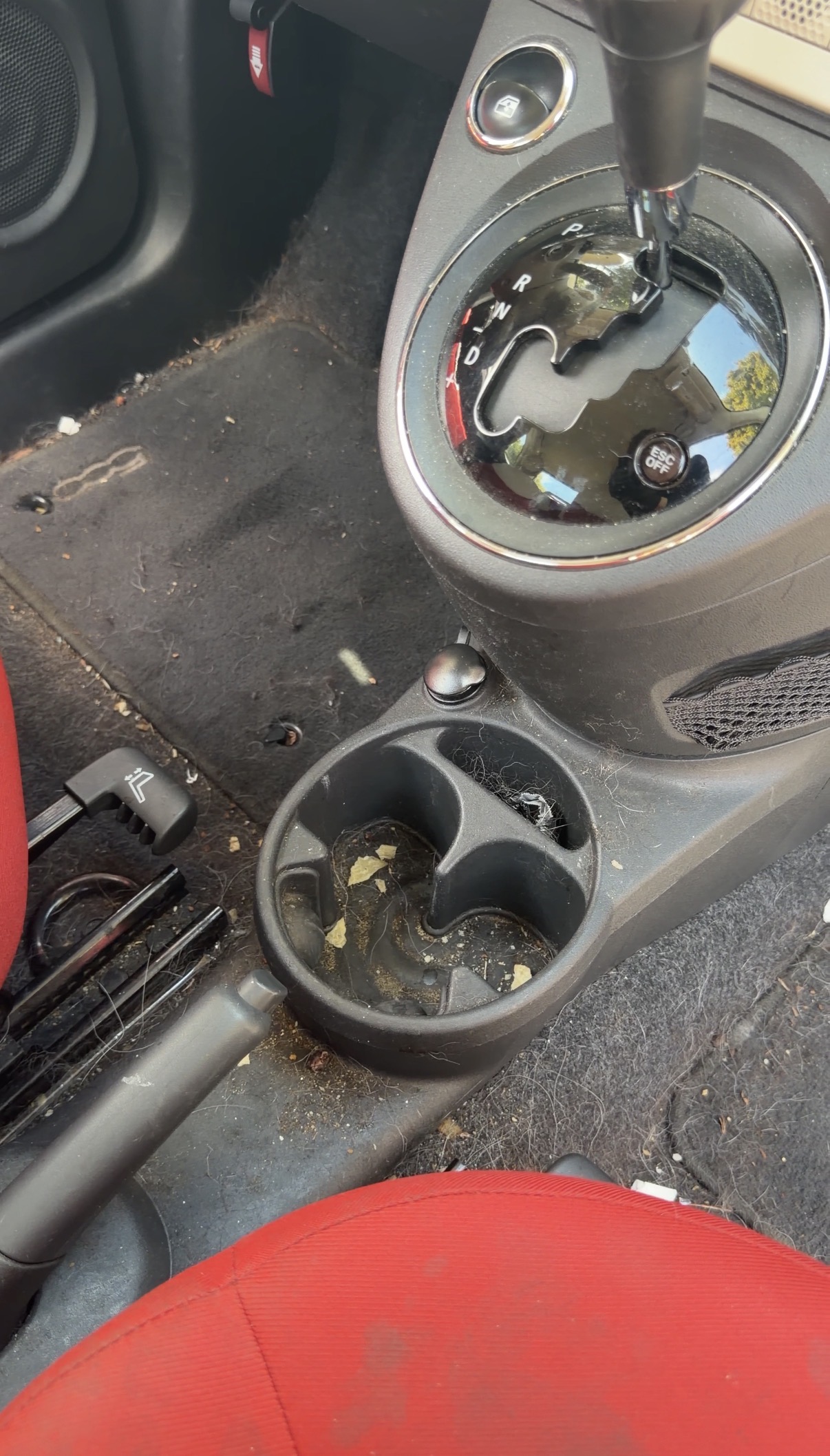 Fiat 500 center console before detailing, crumbs and hair in cup holder
