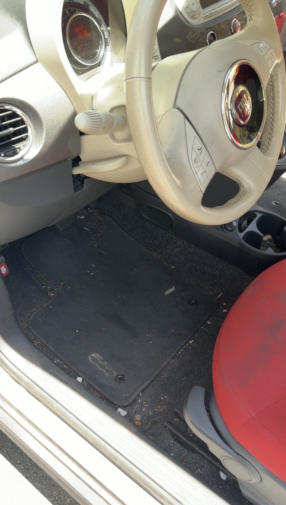 Fiat 500 driver footwell before detailing, dirty carpet