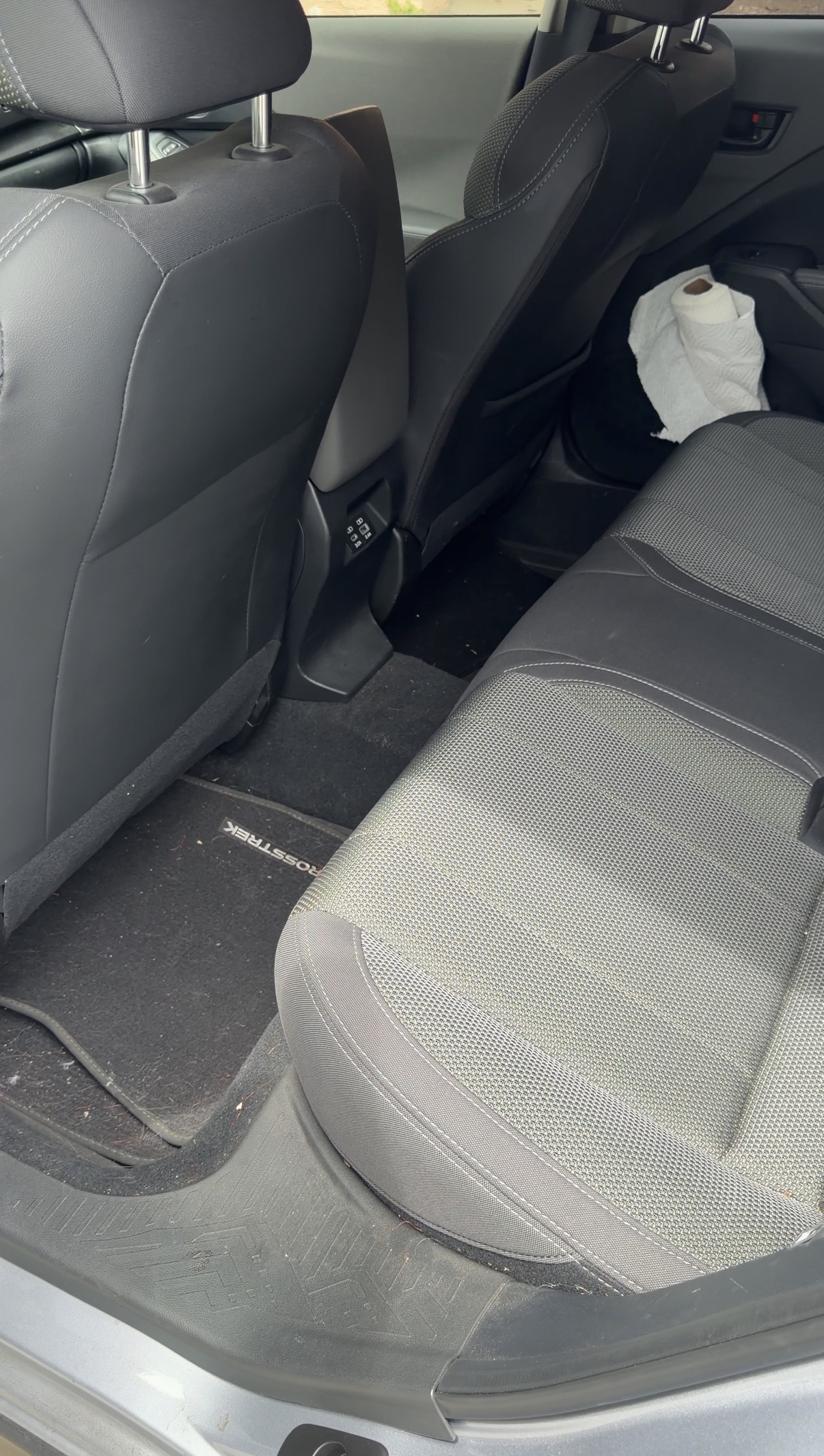 Subaru Crosstrek back seat before detailing, debris on floor