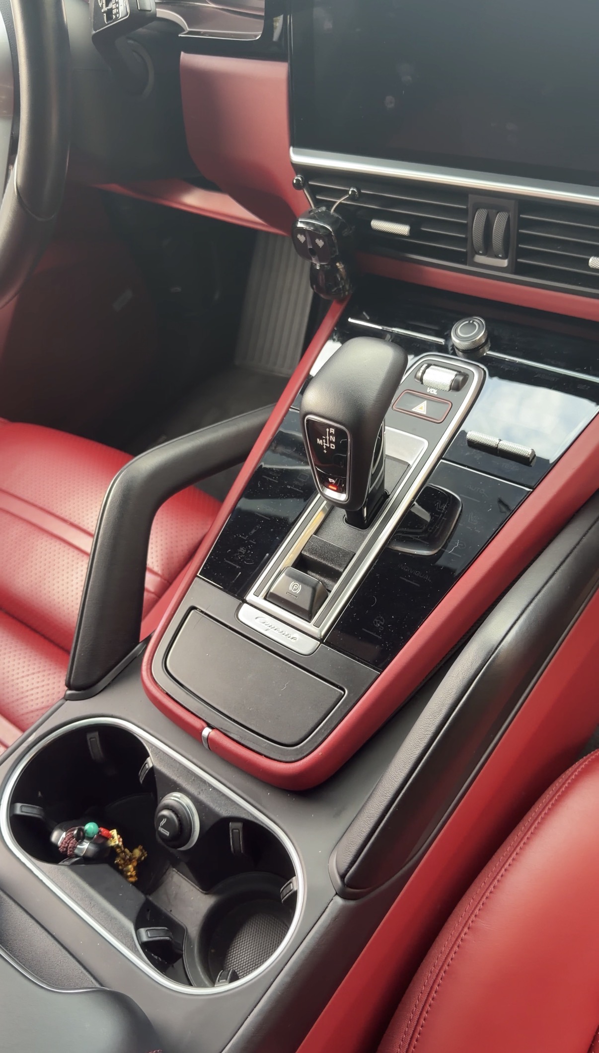 Porsche Cayenne center console before detailing, cluttered cup holder