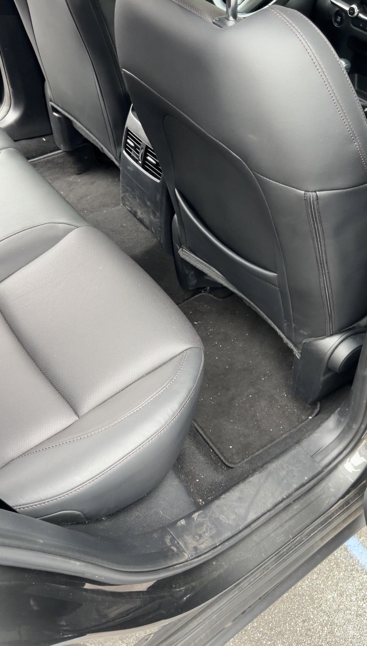 Mazda CX-30 rear seat before detailing, debris scattered on carpet