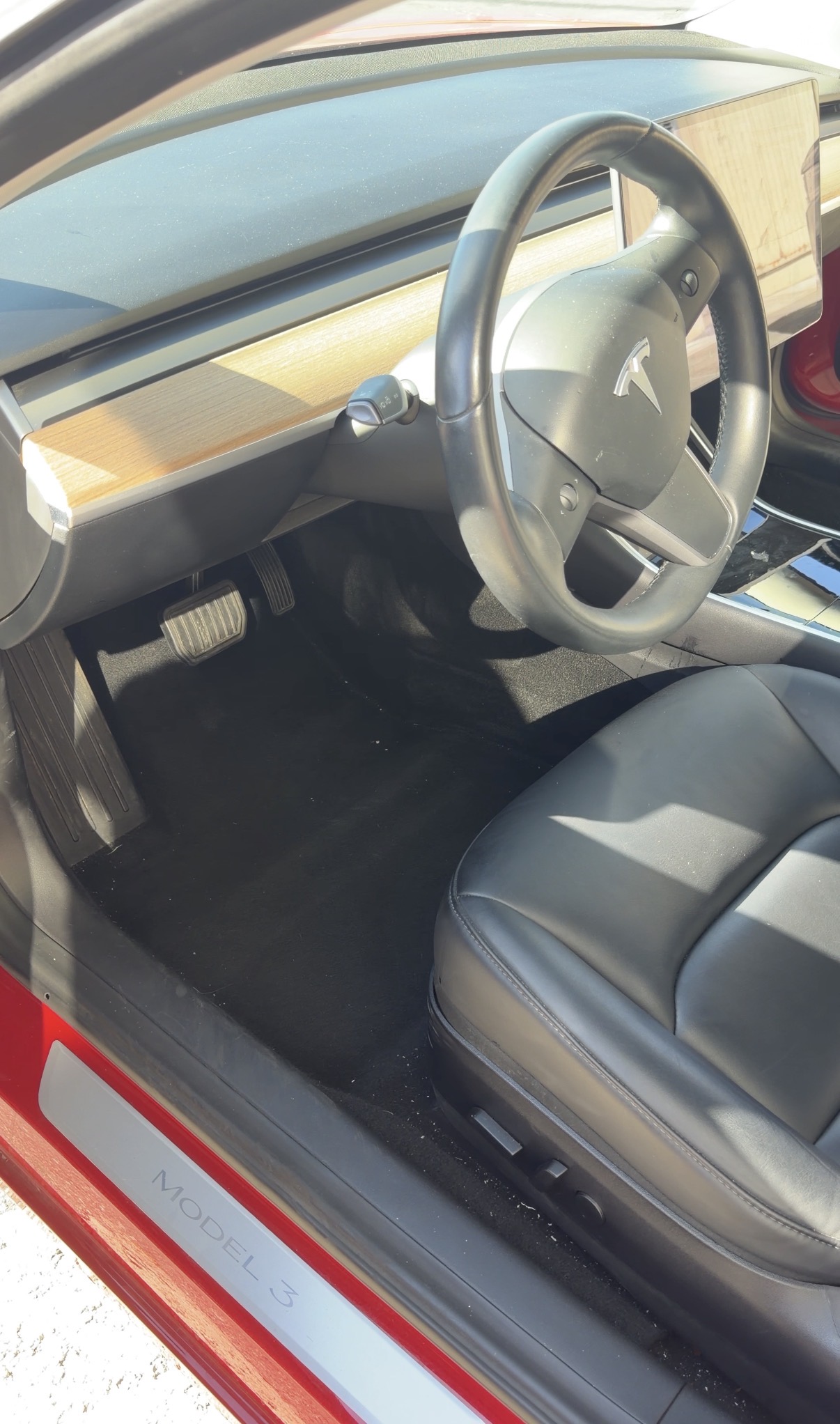Tesla Model 3 driver footwell before detailing, dusty carpet