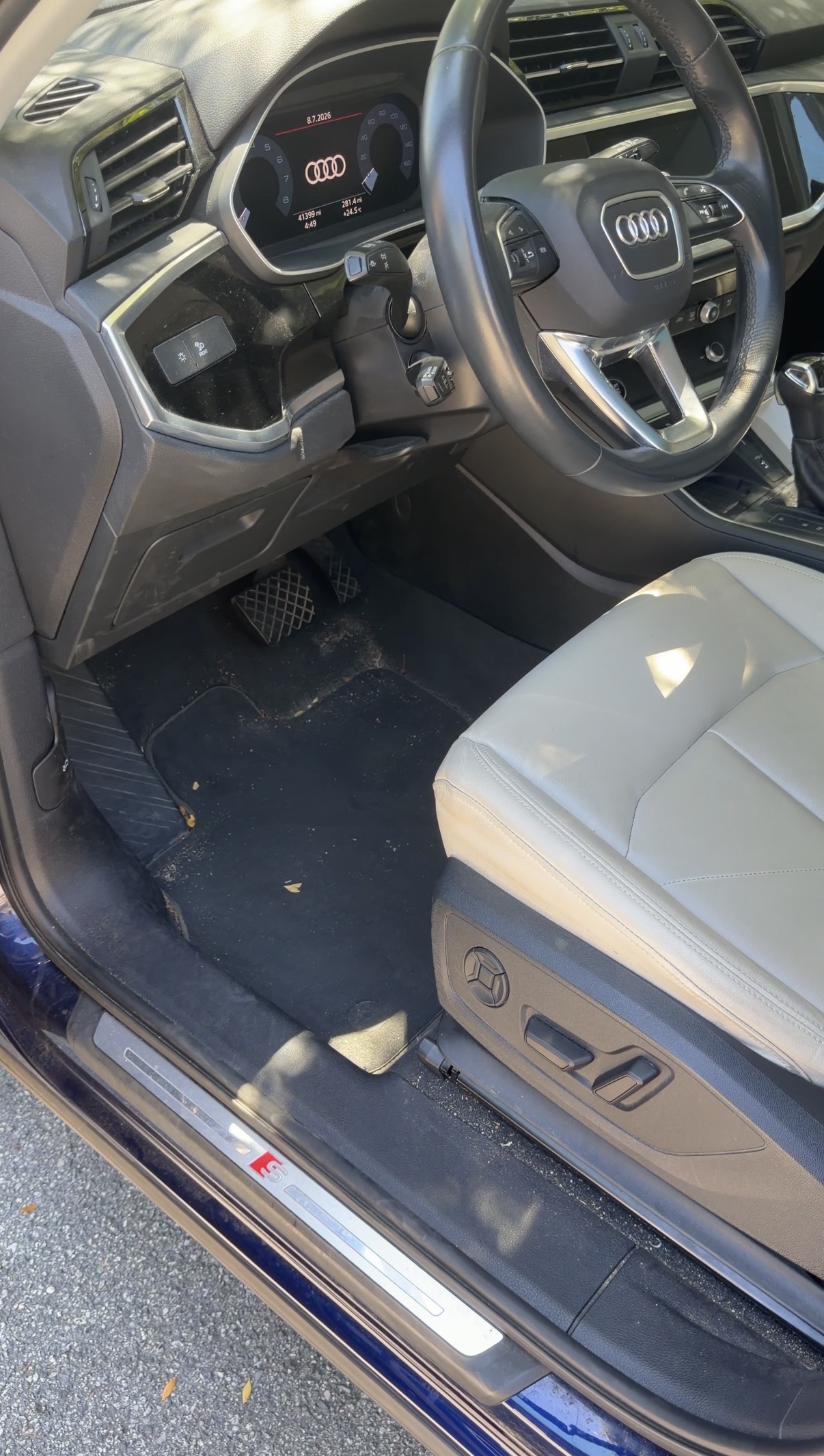 Audi Q3 driver footwell before detailing, dusty carpet
