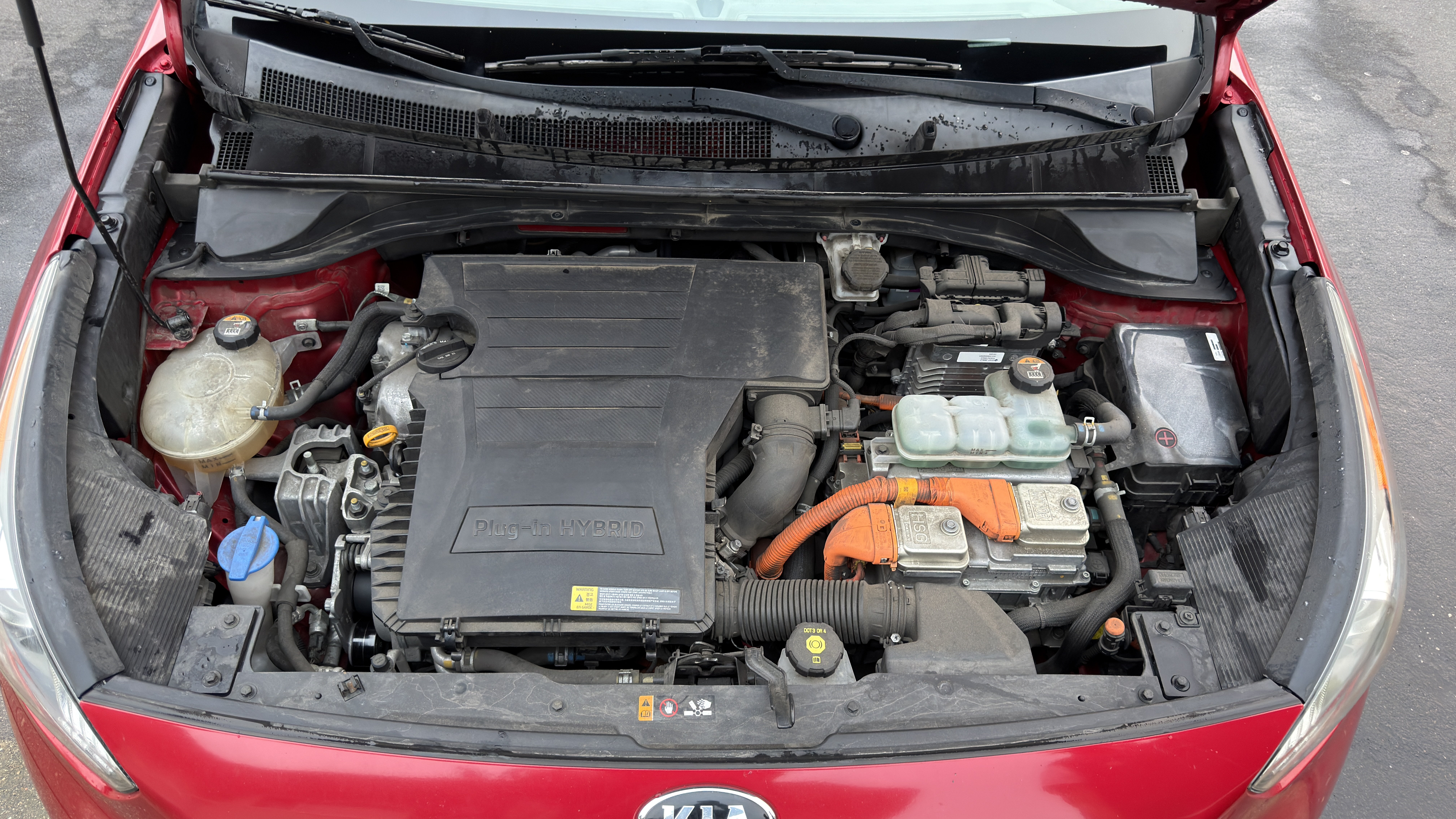 Kia Niro engine bay before service, dusty around the plug-in hybrid engine cover