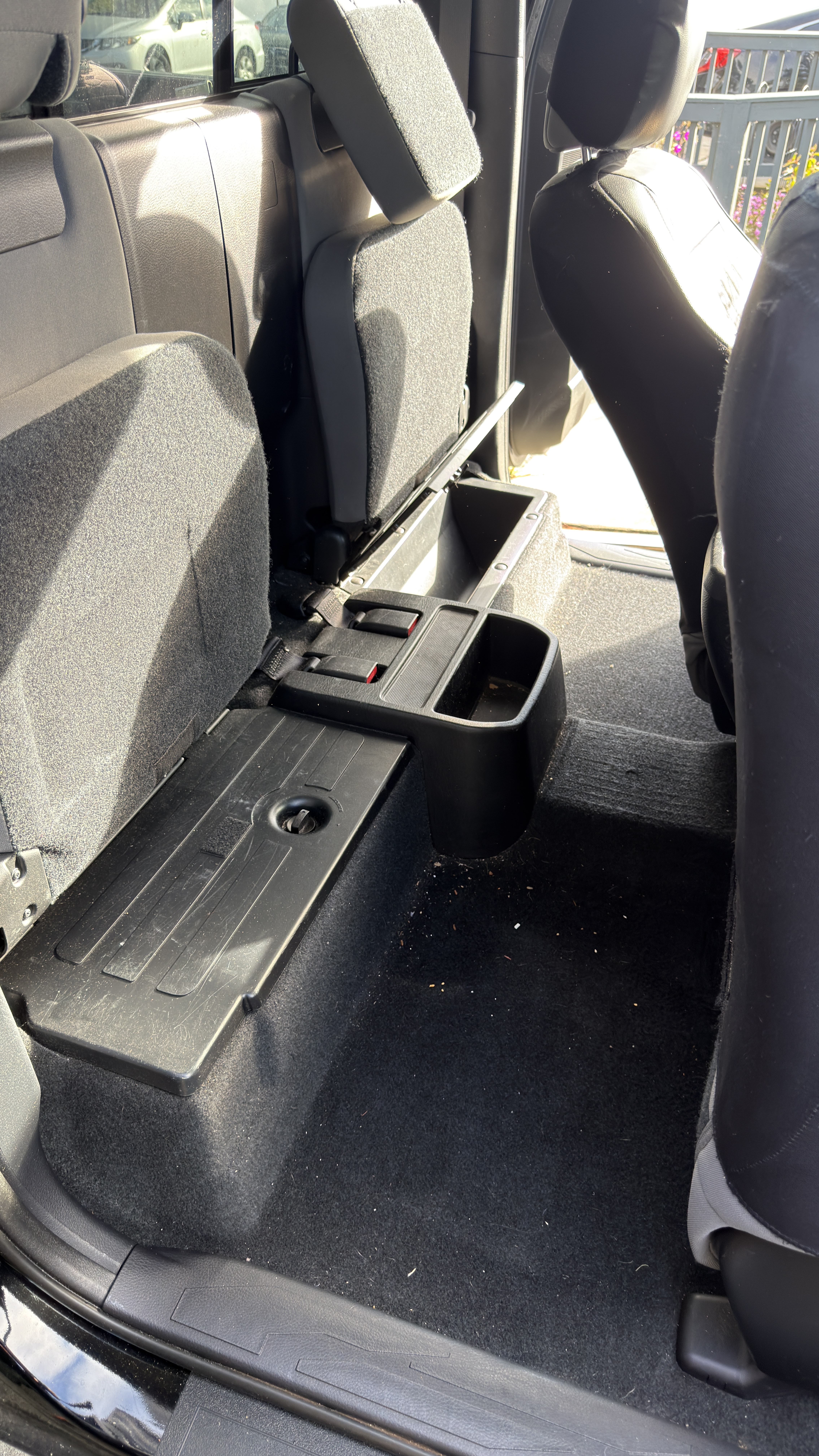 Toyota Tacoma extended cab rear seat before detailing, dusty floor with debris