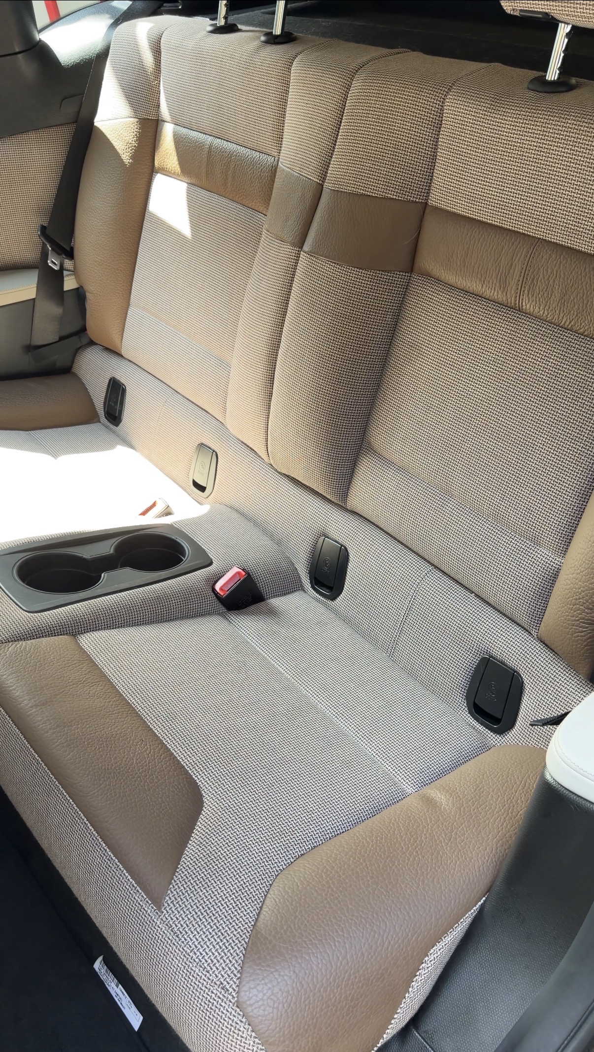 BMW i3 driver footwell after detailing, clean carpet with steering wheel visible