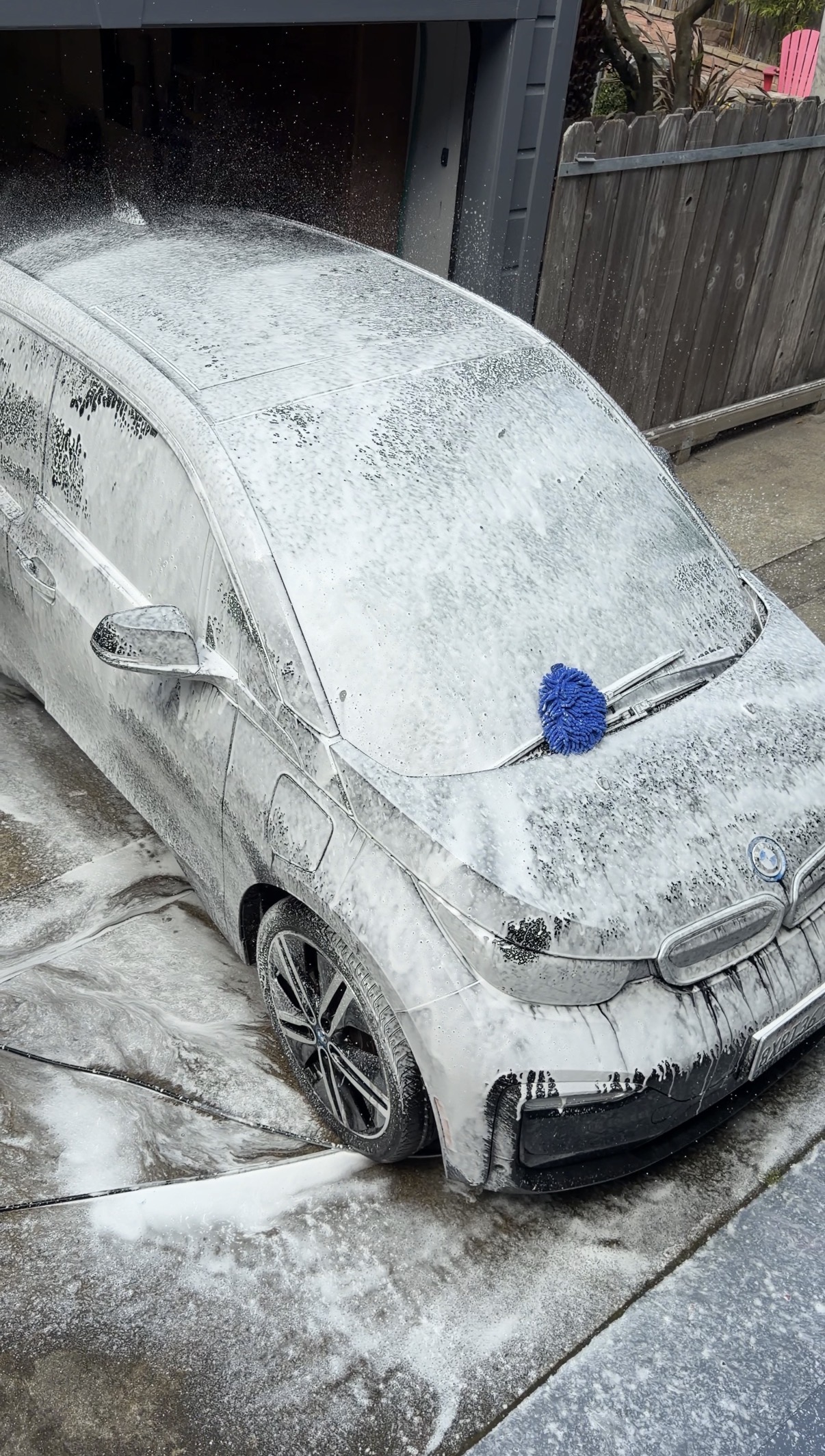 BMW i3 covered in snow foam during mobile detailing pre-wash in a Noe Valley driveway