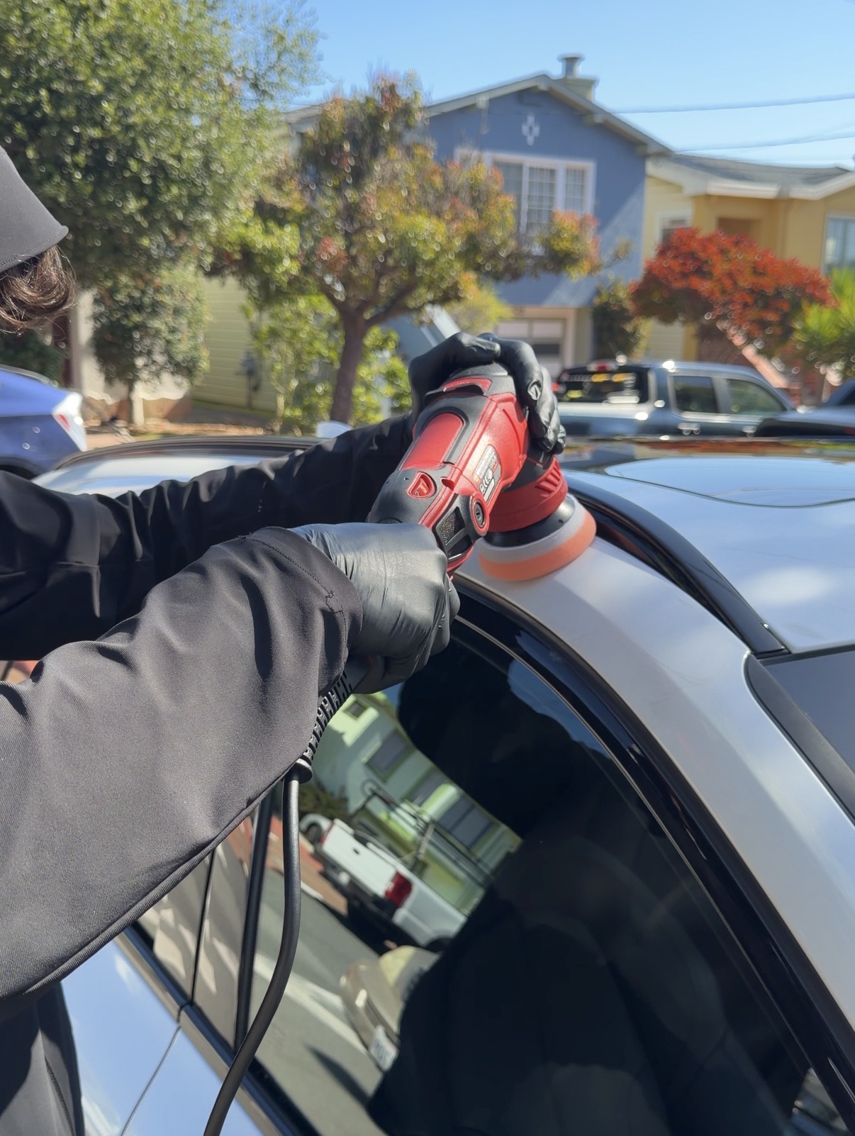 Rotary polisher on black car roof