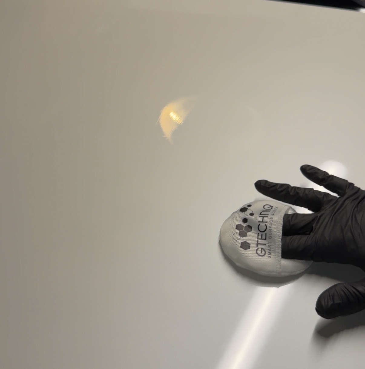 Ceramic coating being applied to a vehicle's paint with a Gtechniq applicator pad