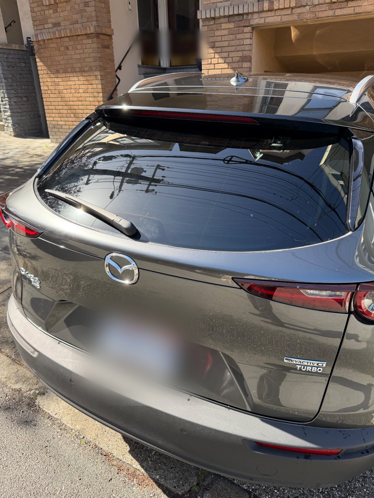 Rear of a grey Mazda CX-30 after a wash showing the Skyactiv-G Turbo badge