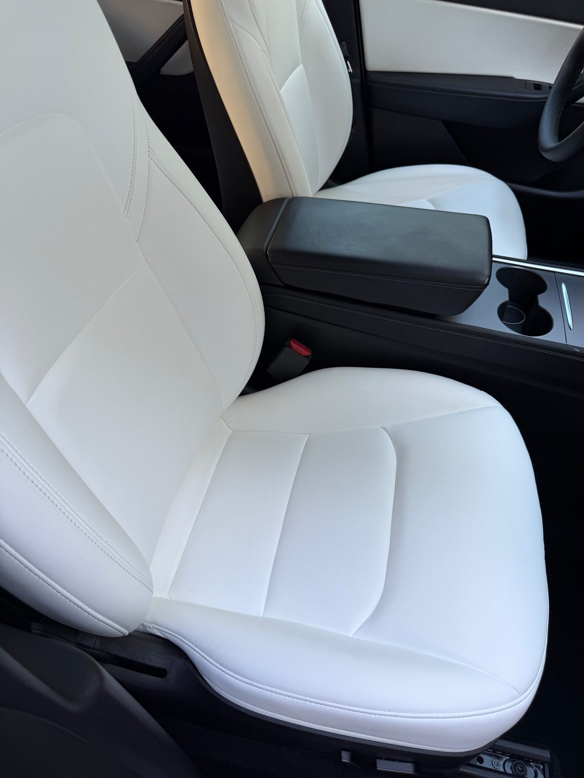 Clean white leather front seat of a Tesla Model Y after detailing