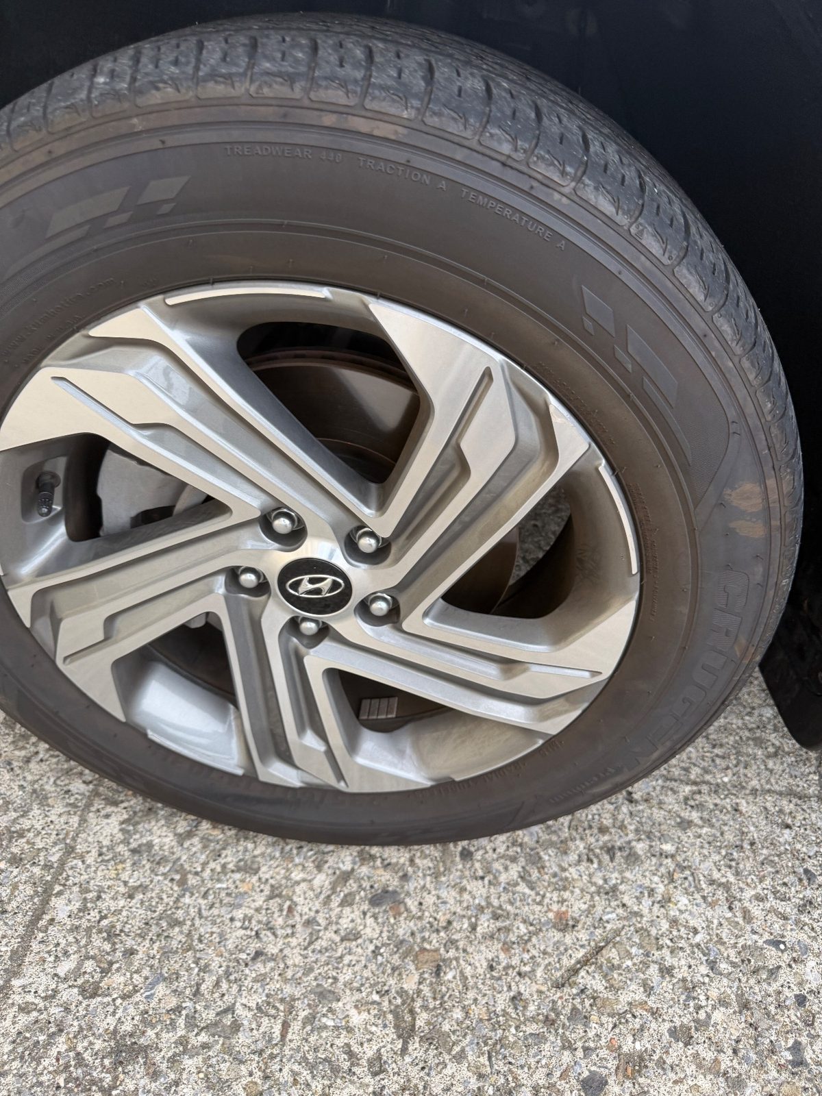 Close-up of a dusty alloy wheel and dull sidewall on a Hyundai Santa Fe before detailing