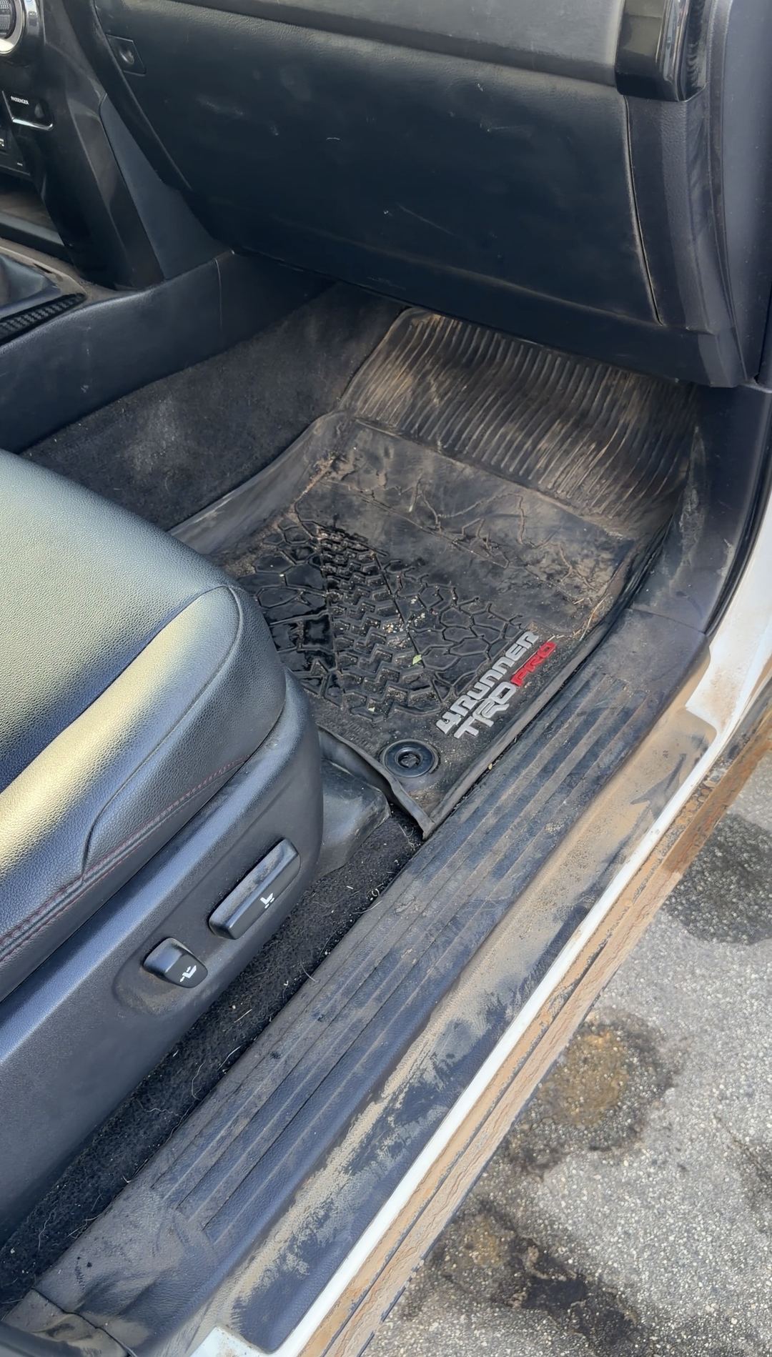 Muddy 4Runner TRD Pro floor mat and dirty door sill in a Toyota 4Runner front passenger footwell