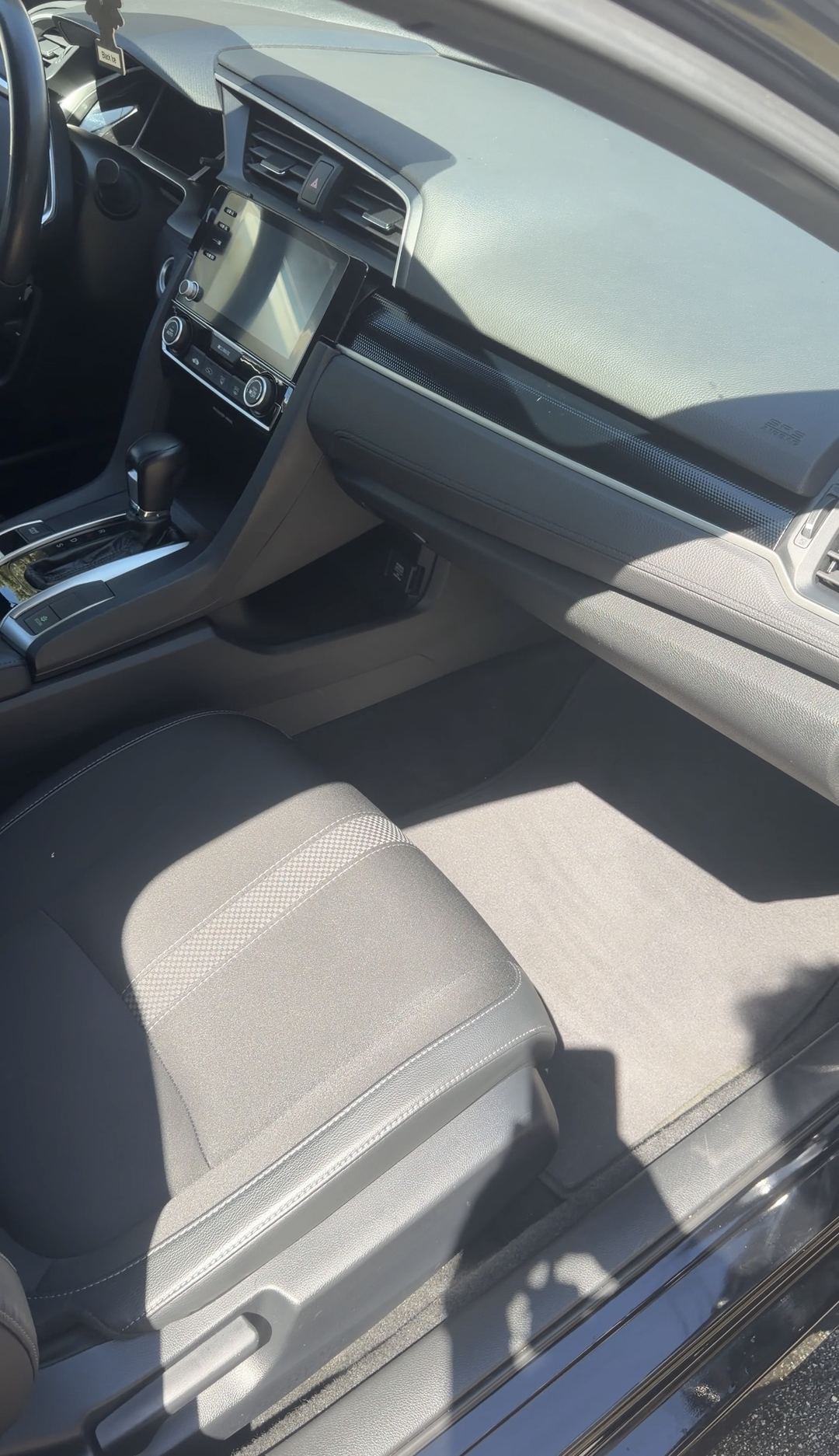 Clean front passenger floor mat and dash of a Honda Civic after the interior detail