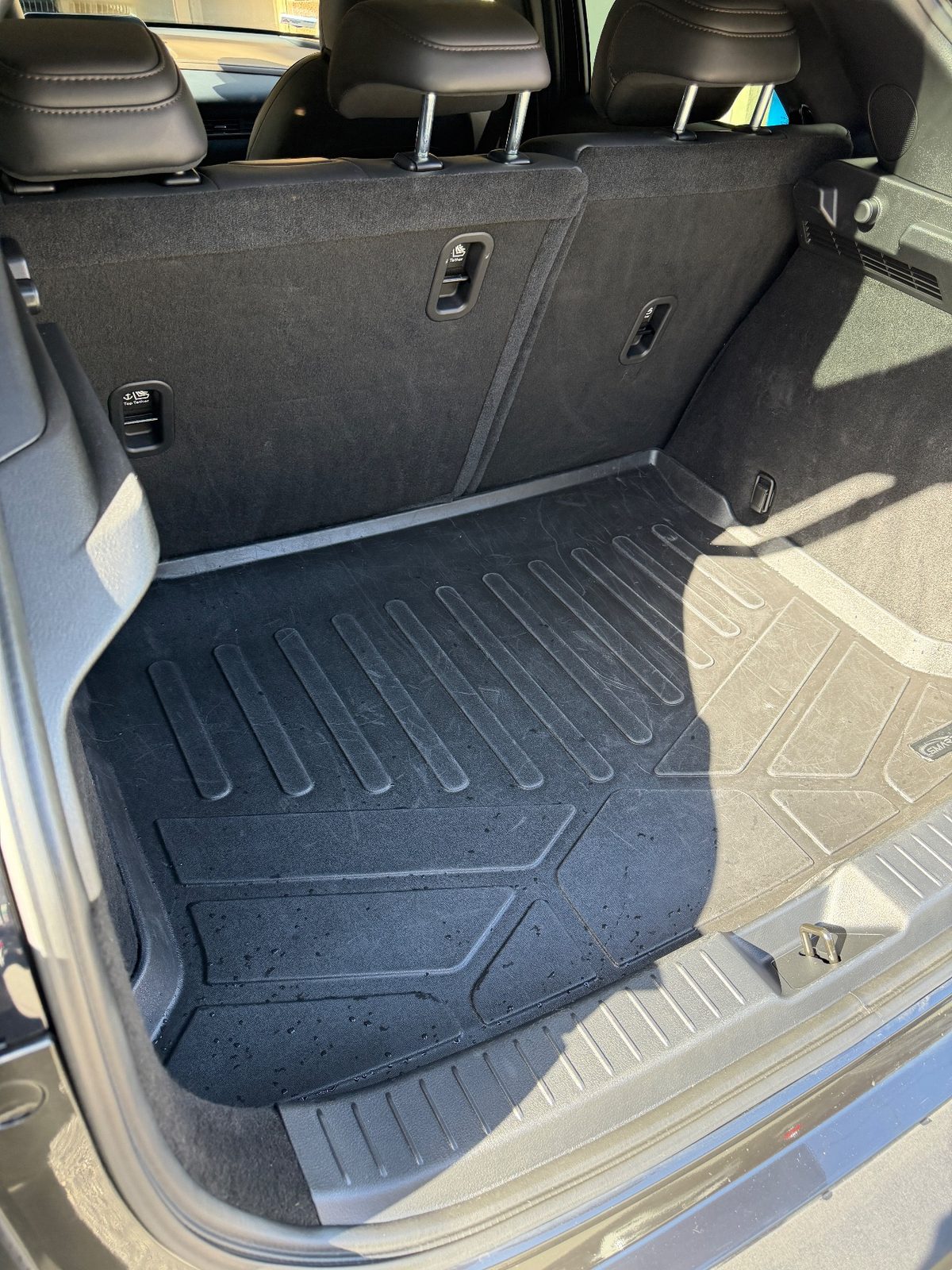 Cargo area of a grey Mazda CX-30 after detailing, clean liner with the seats up