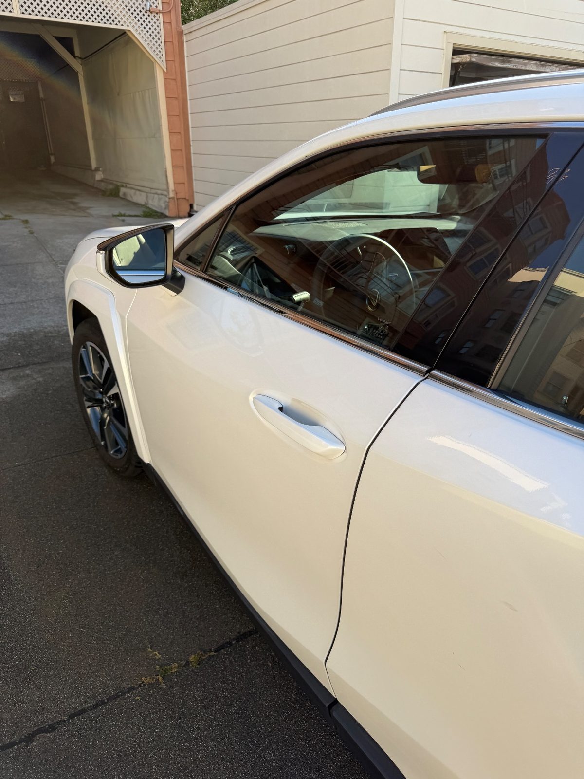 Clean white Lexus UX front door and mirror after detailing