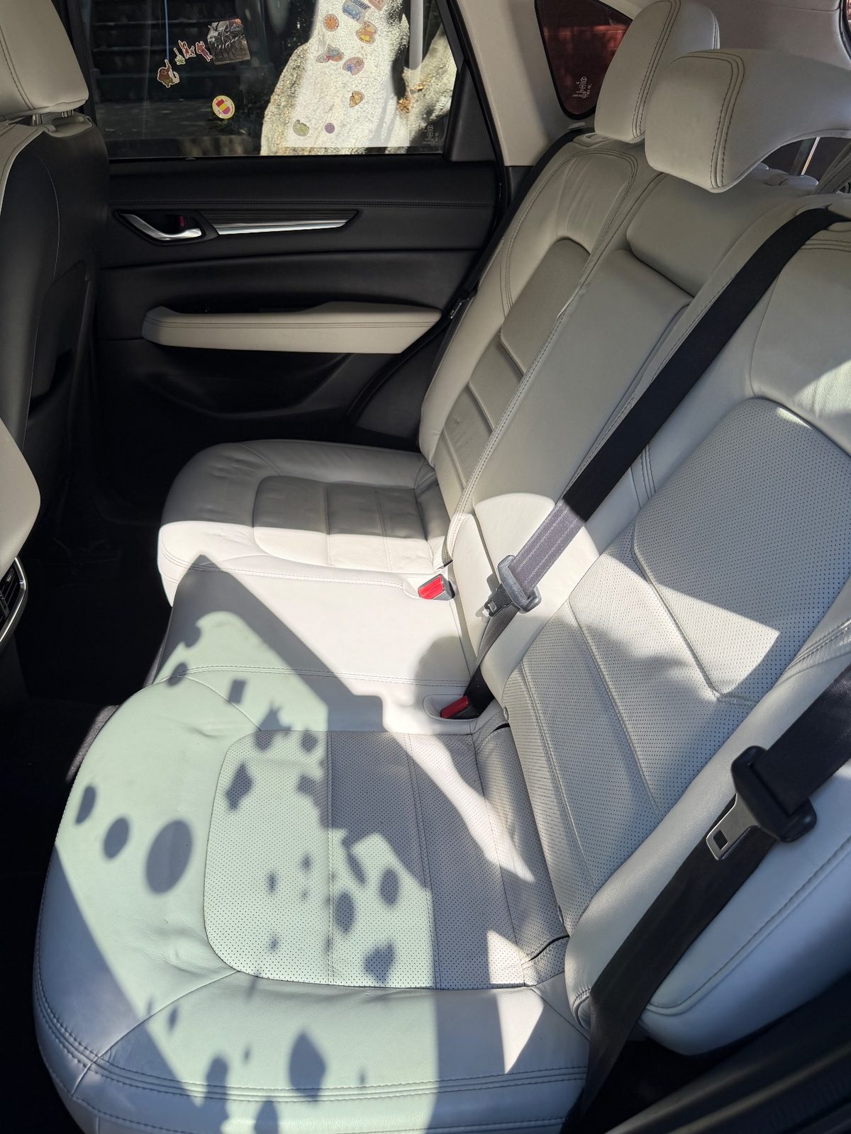 Clean rear seat of a dark blue Mazda CX-5 after cleaning, cream leather free of stains