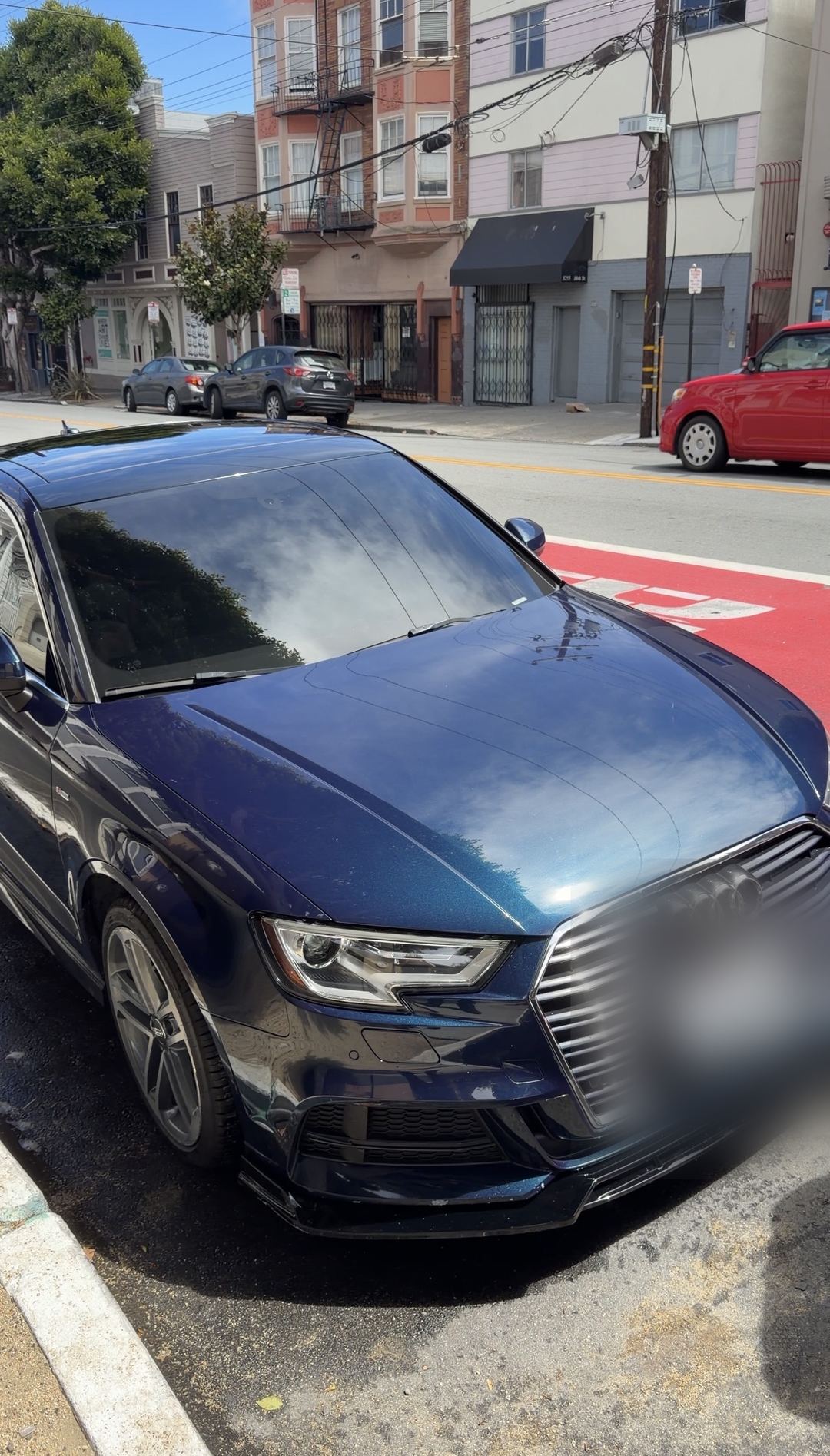 Freshly detailed navy Audi A3 sedan parked on a San Francisco street, seen from the front-left with a deep gloss finish.