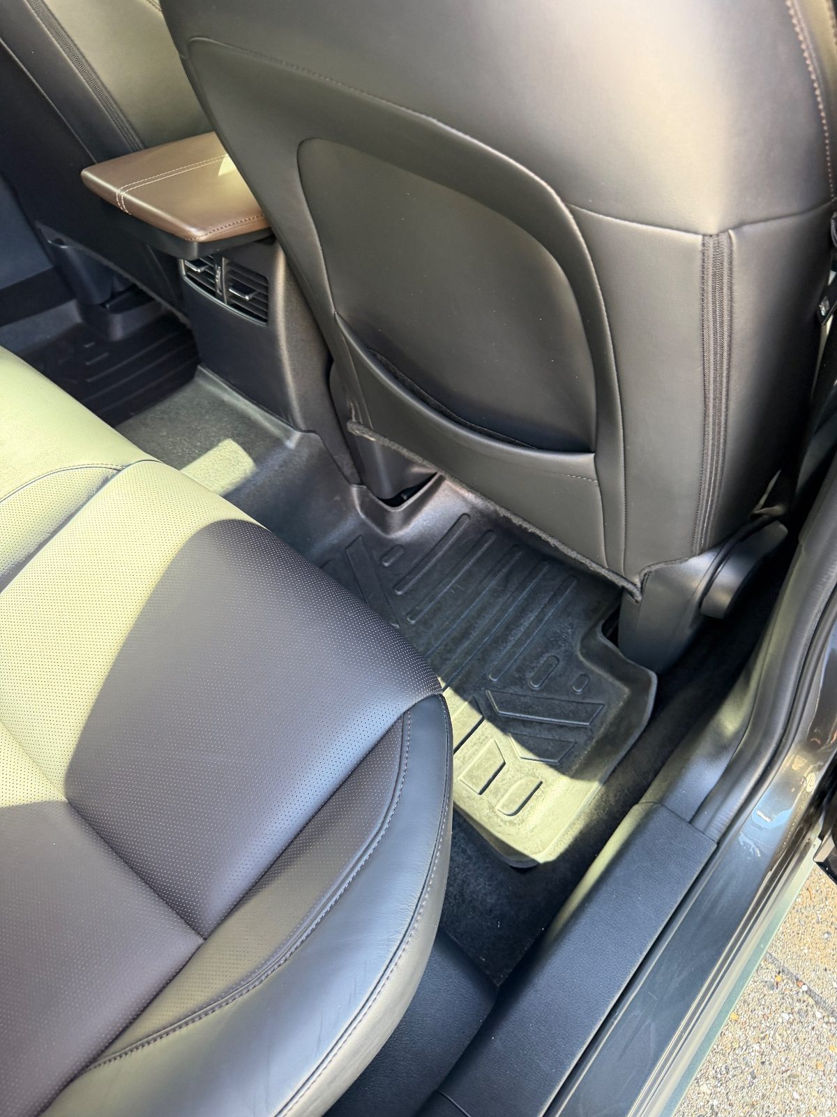 Rear footwell of a grey Mazda CX-30 after detailing, clean liner and empty seat-back pocket