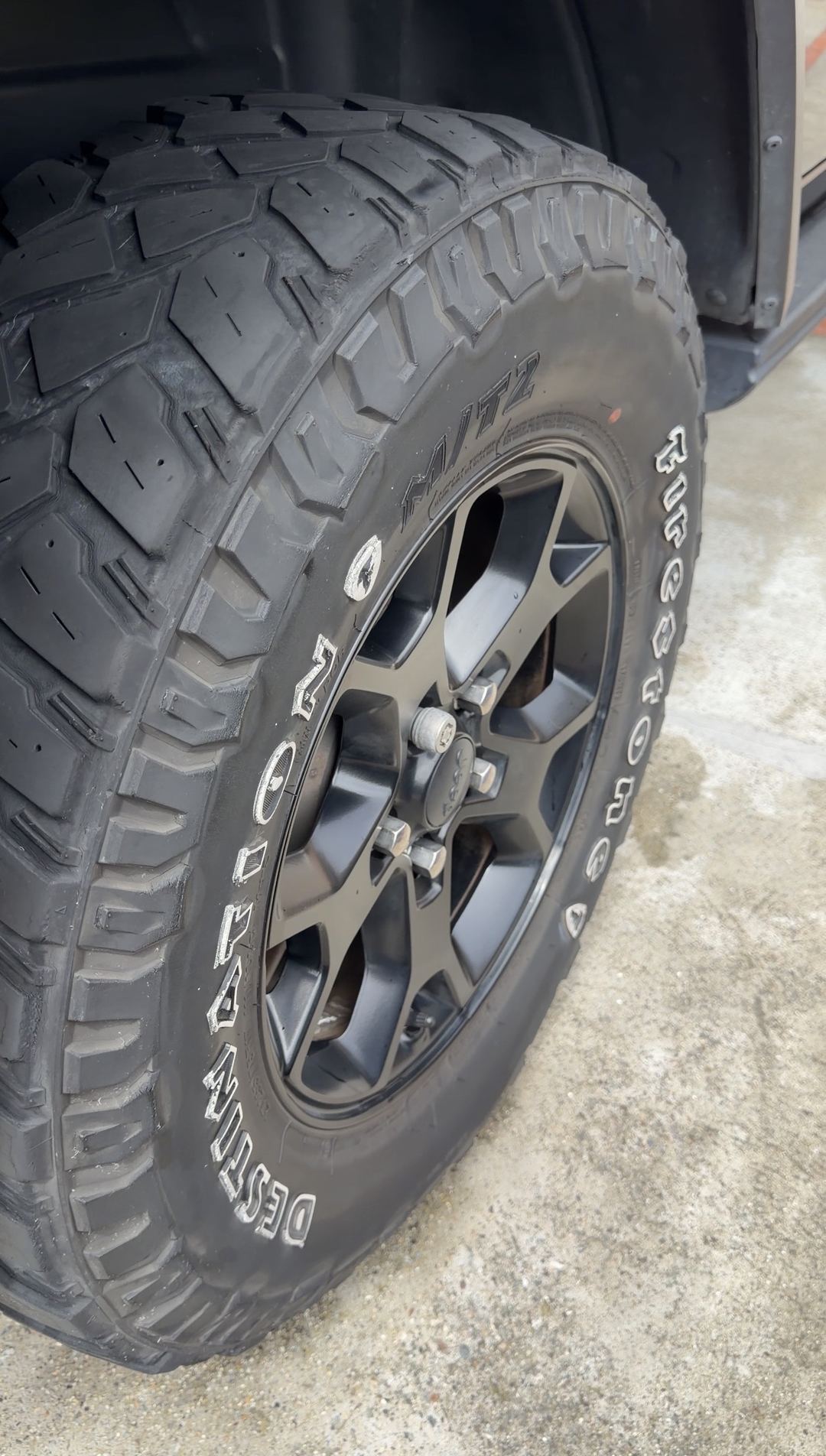 Clean black wheel and Firestone Destination M/T2 tyre on a Jeep Wrangler after cleaning