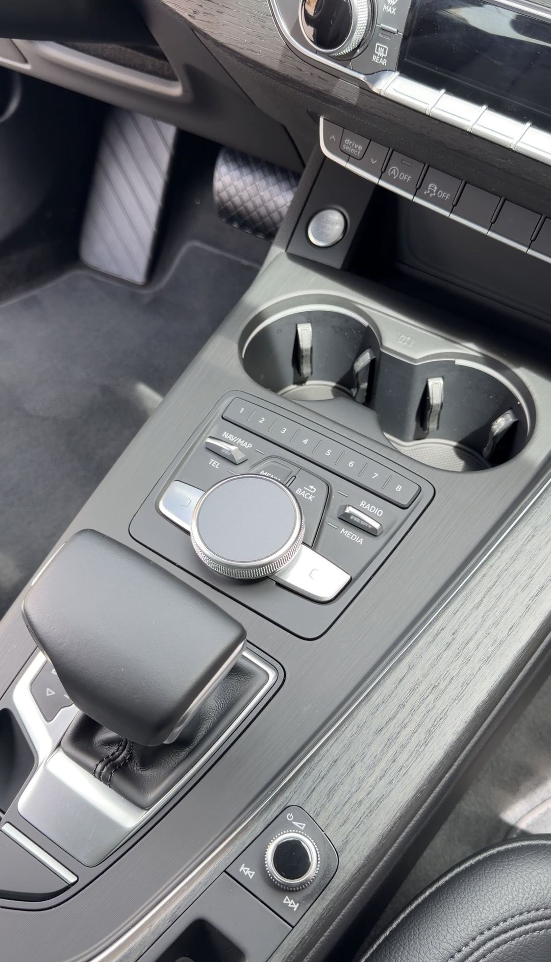 Clean cupholders, MMI controller and gear selector in the centre console of an Audi A4