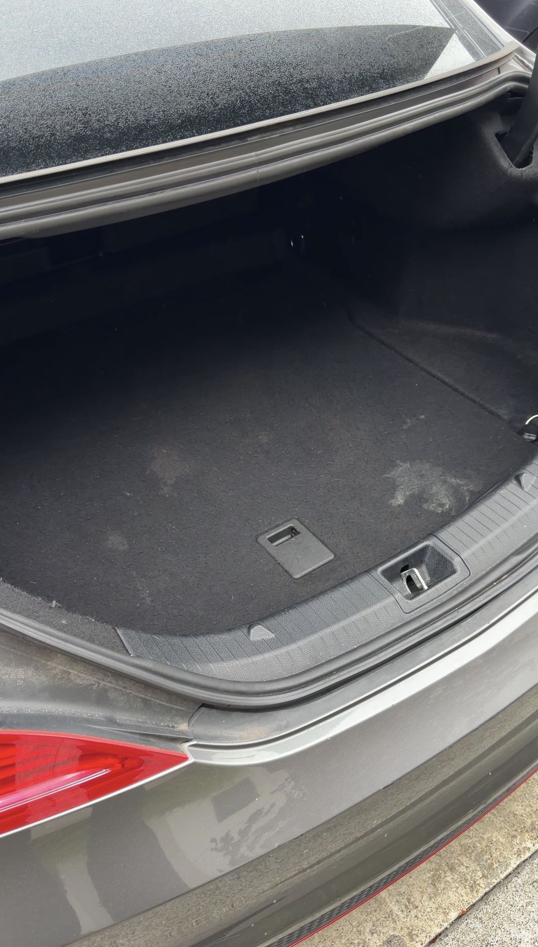 Boot of a grey Mercedes-Benz CLA250 before detailing, with pale crusty deposits on the carpet