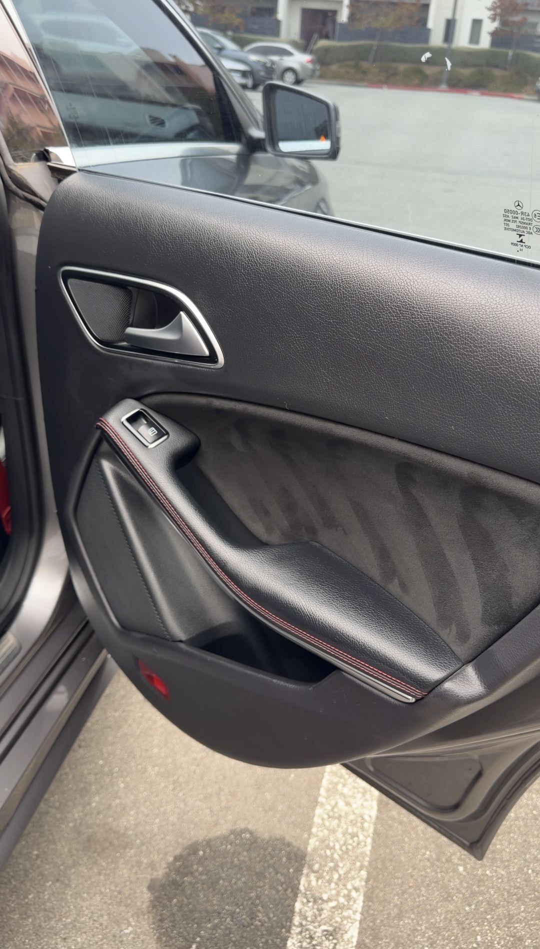 Clean rear door card of a Mercedes-Benz CLA250 with grey microfibre insert and red stitching