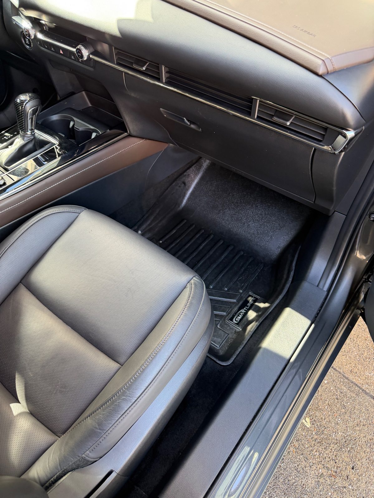 Front passenger footwell of a grey Mazda CX-30 after detailing, spotless liner
