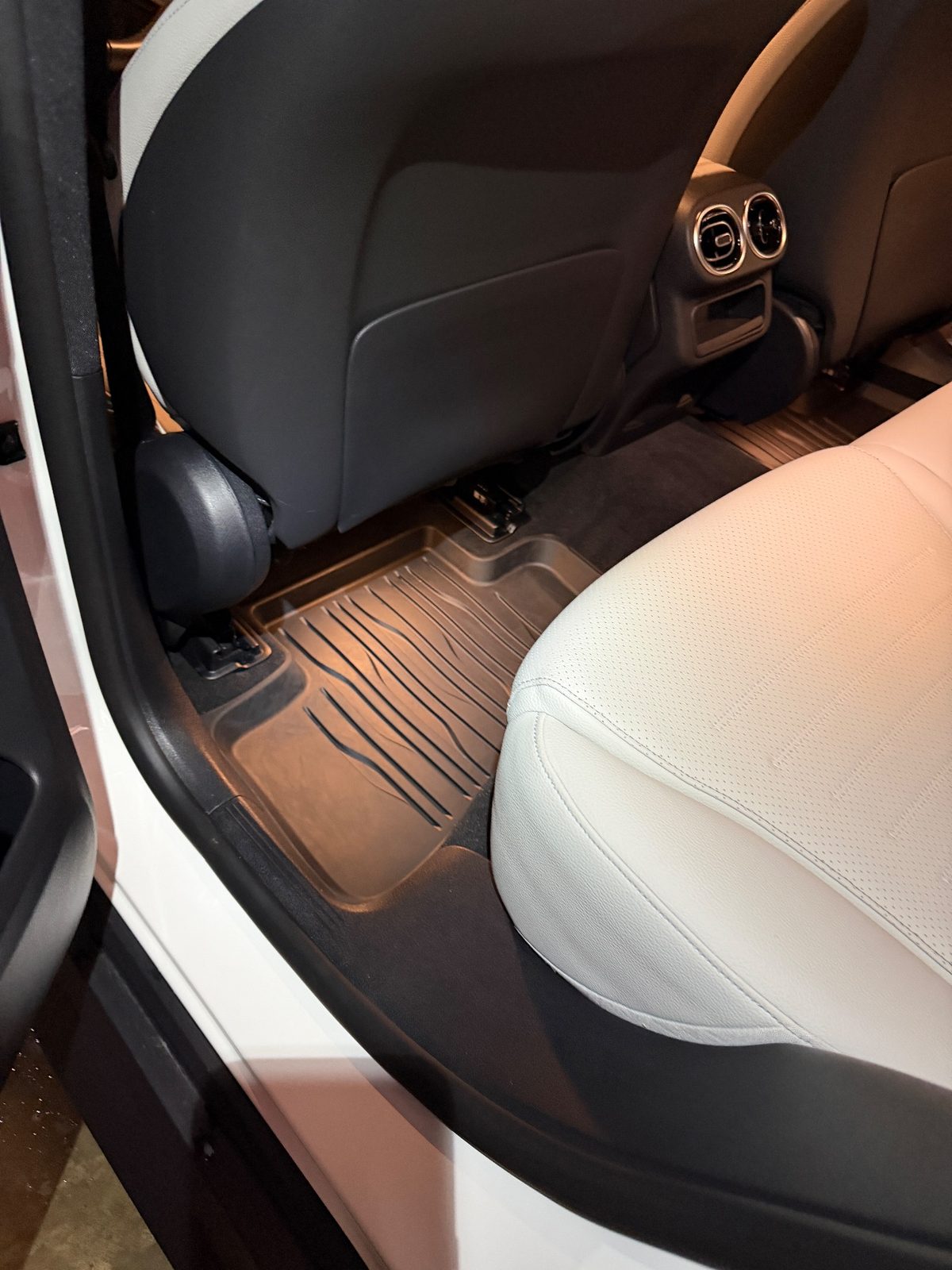 Rear footwell of a white Mercedes GLC after detailing, clean mat and carpet