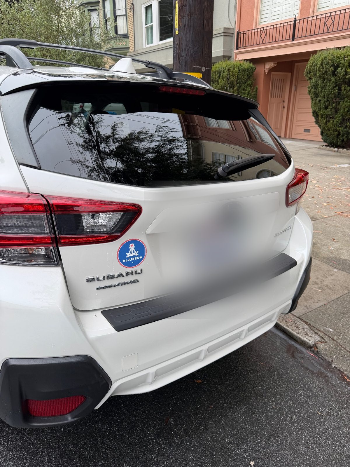 Rear of a clean white Subaru Crosstrek after washing with glossy paint and clear glass