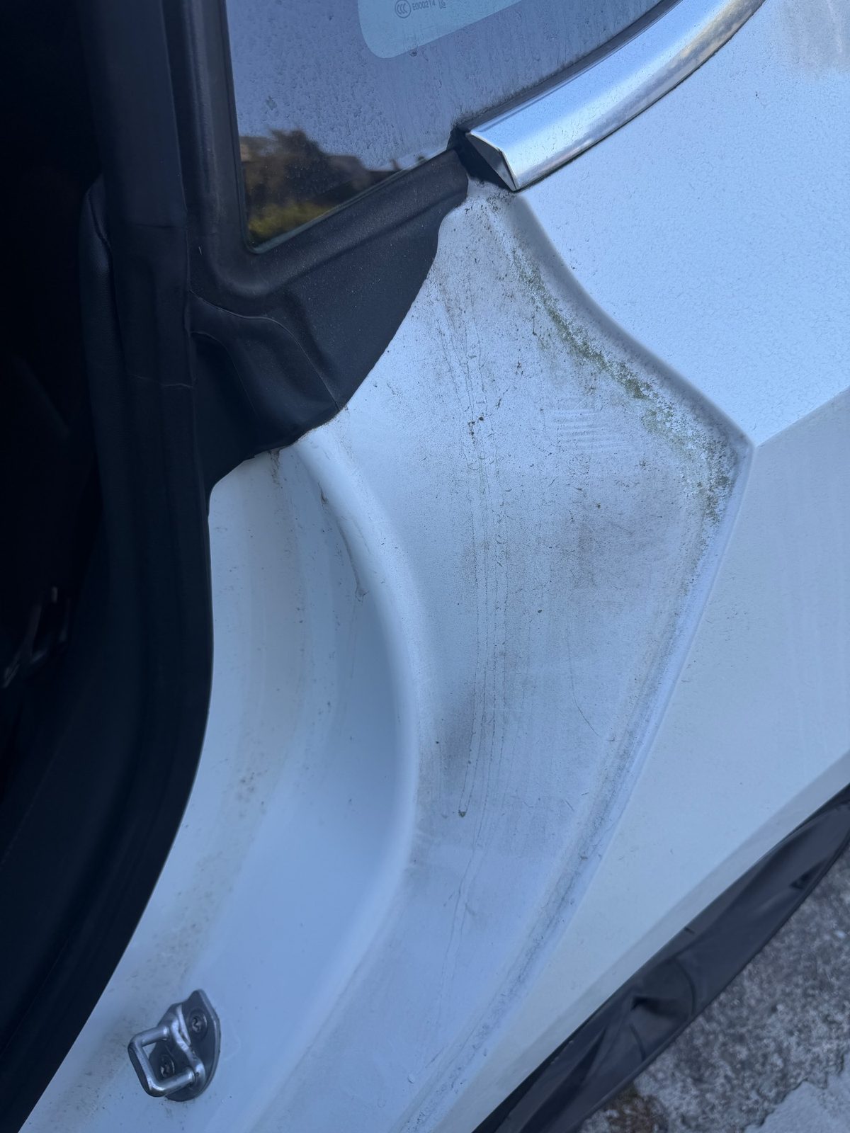 Grimy door shut and quarter panel on a white Tesla Model 3 before detailing
