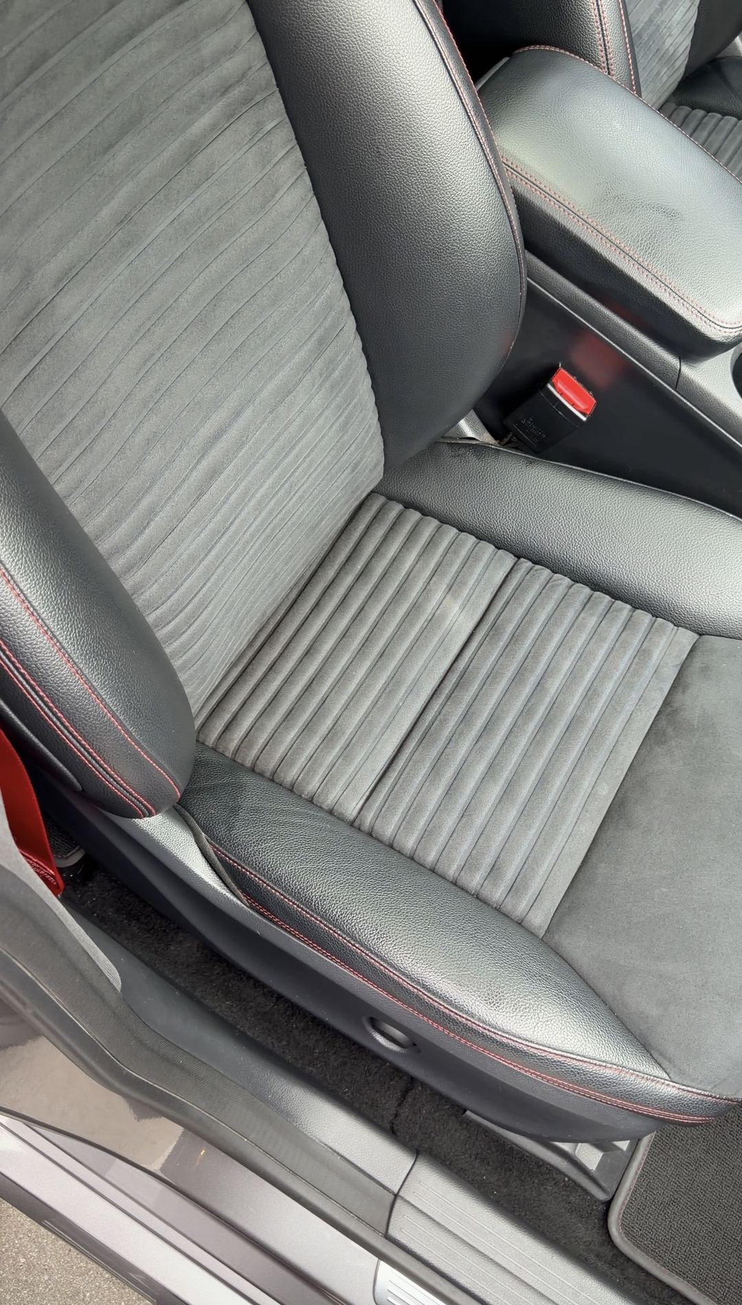 Close view of a cleaned grey microfibre Mercedes-Benz CLA250 front seat with red contrast stitching