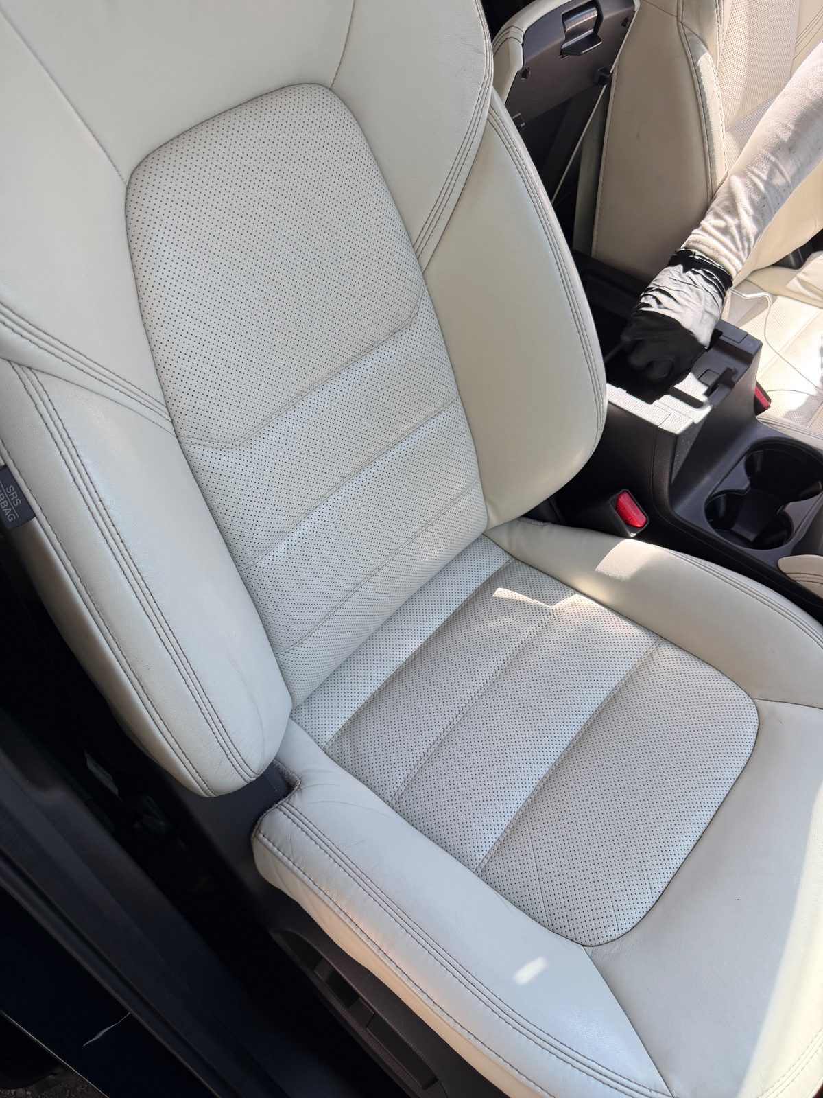 Clean front passenger seat of a dark blue Mazda CX-5 after cleaning, cream leather bright and even