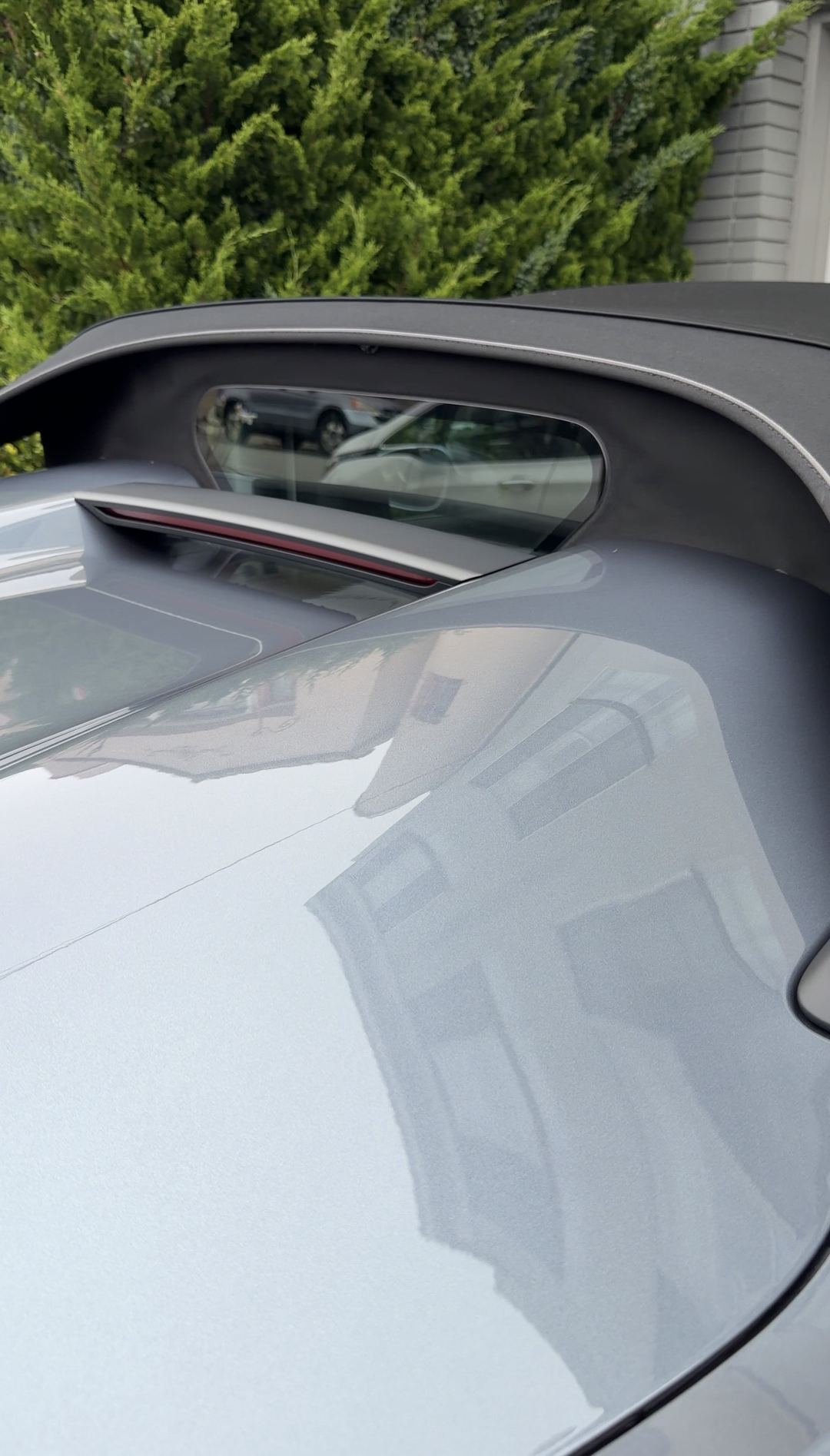Rear deck and soft-top rear window of a clean grey Porsche 718 Spyder RS.