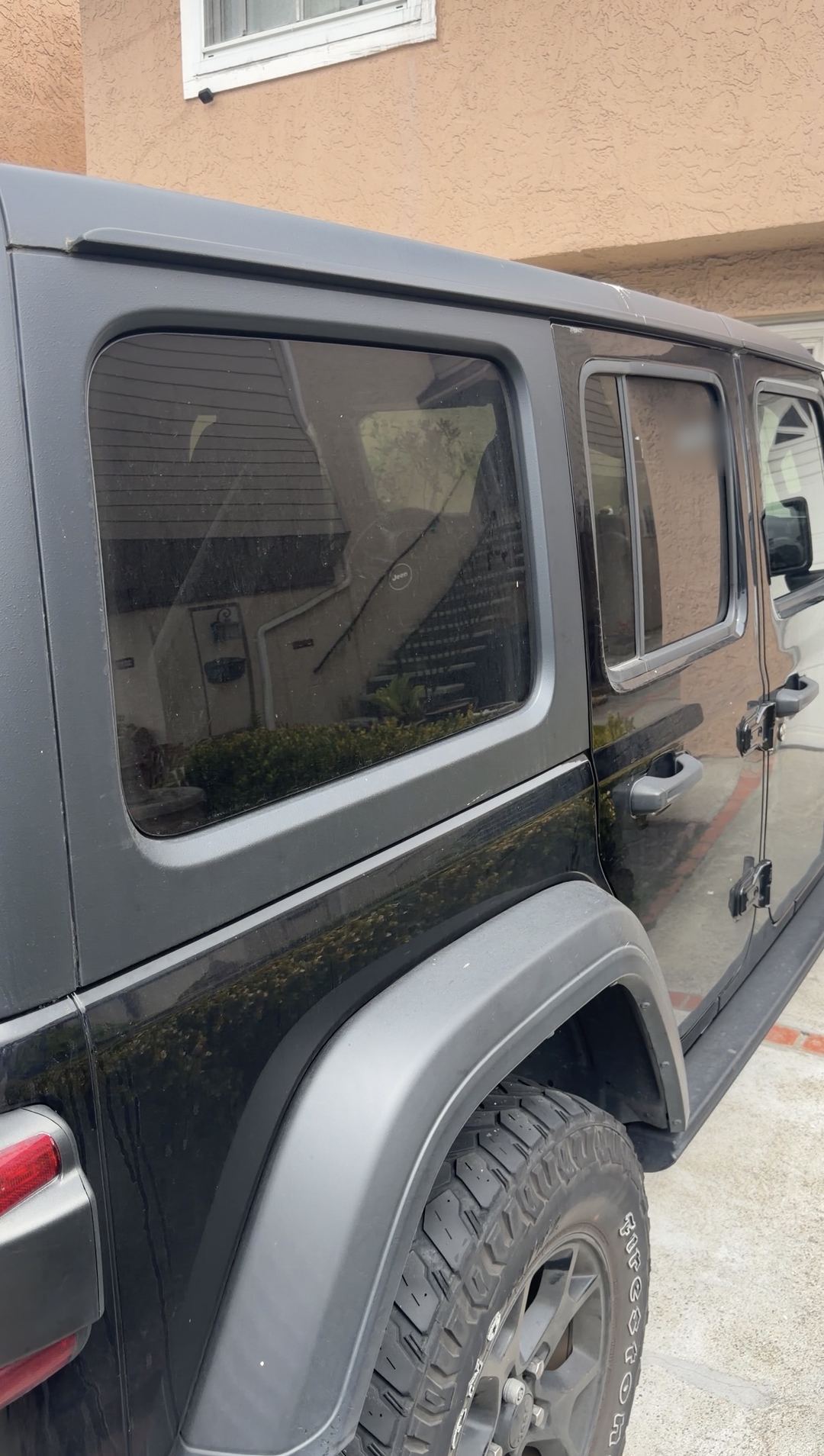 Black Jeep Wrangler rear quarter, side windows and fender flare before cleaning