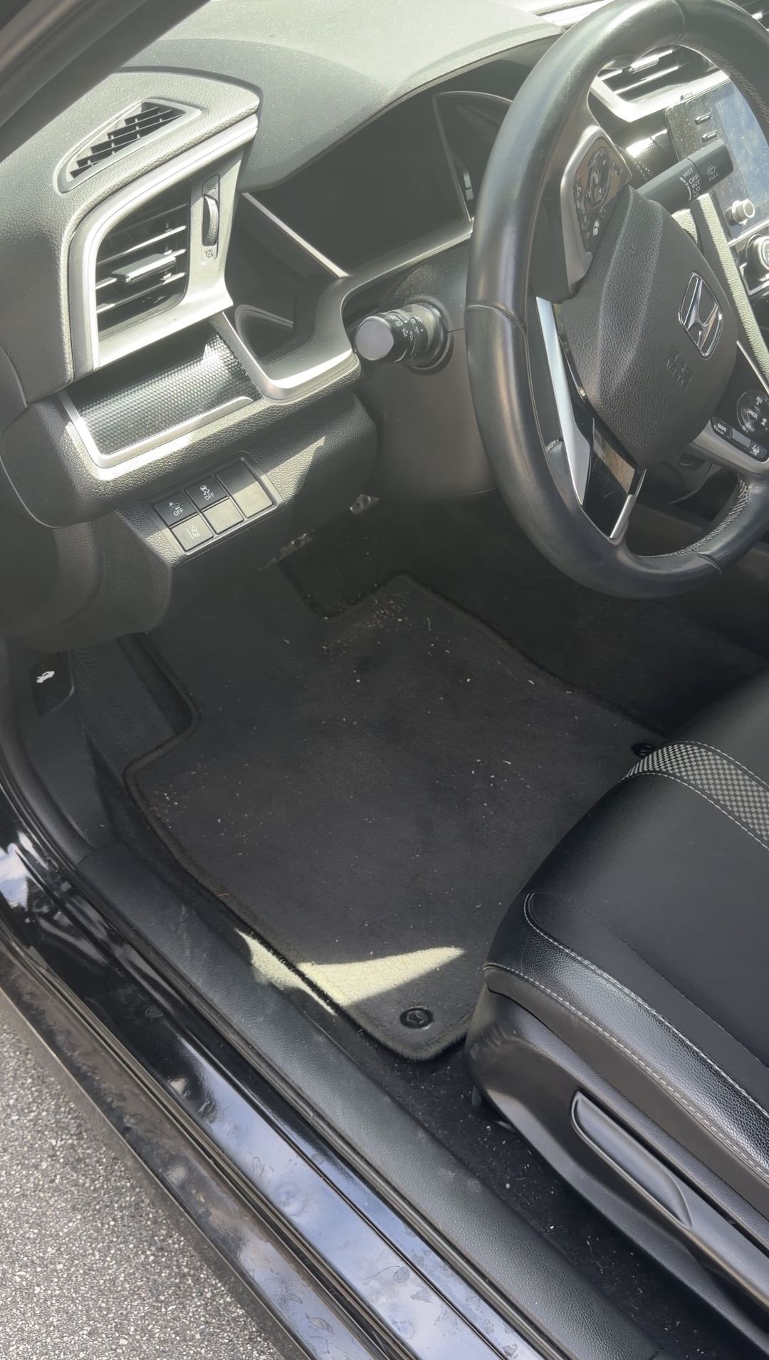 Dirty driver floor mat and dash of a Honda Civic before the interior detail