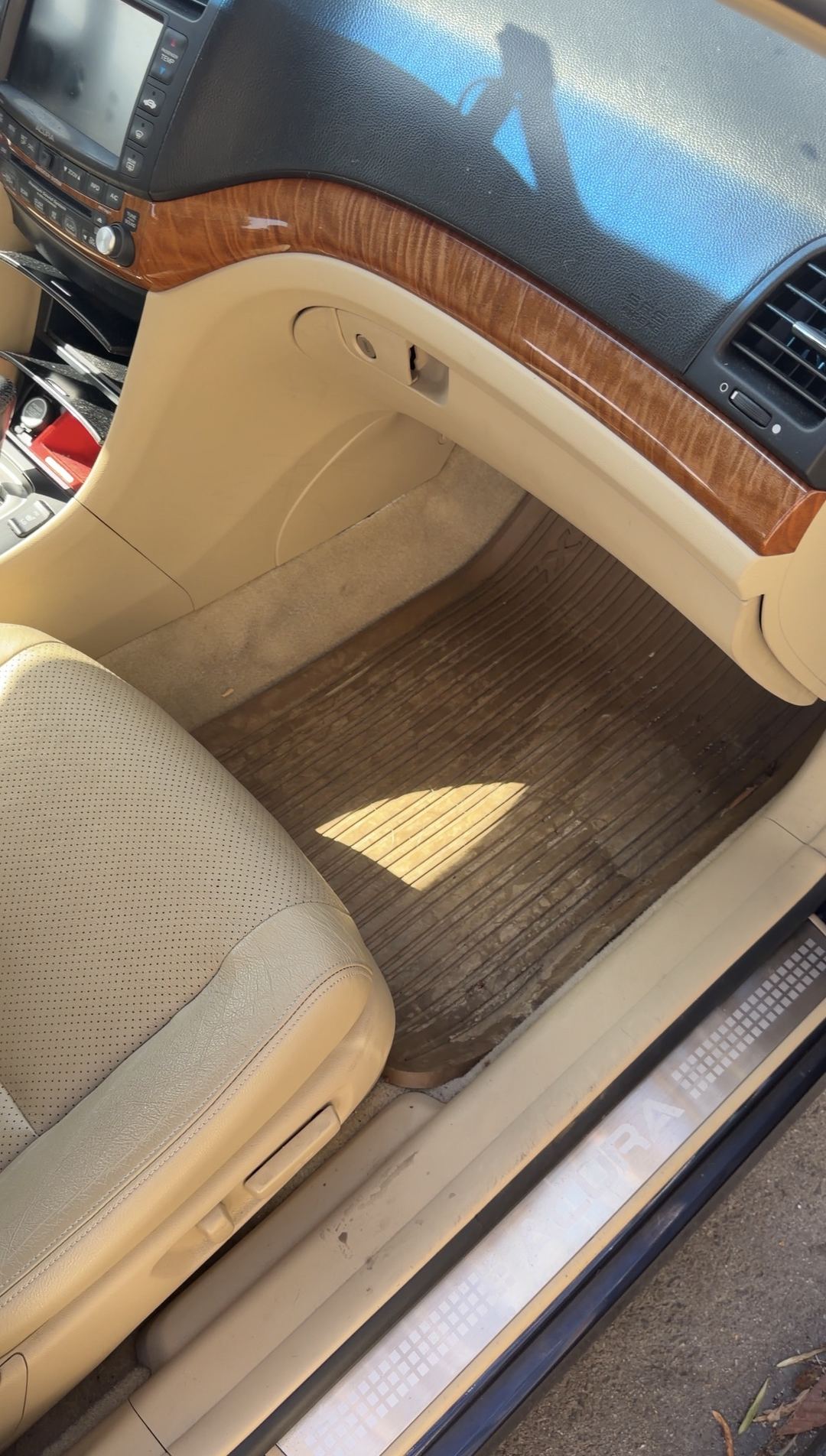 Front passenger footwell of an Acura sedan before detailing, with a rubber floor mat caked in dried dirt.